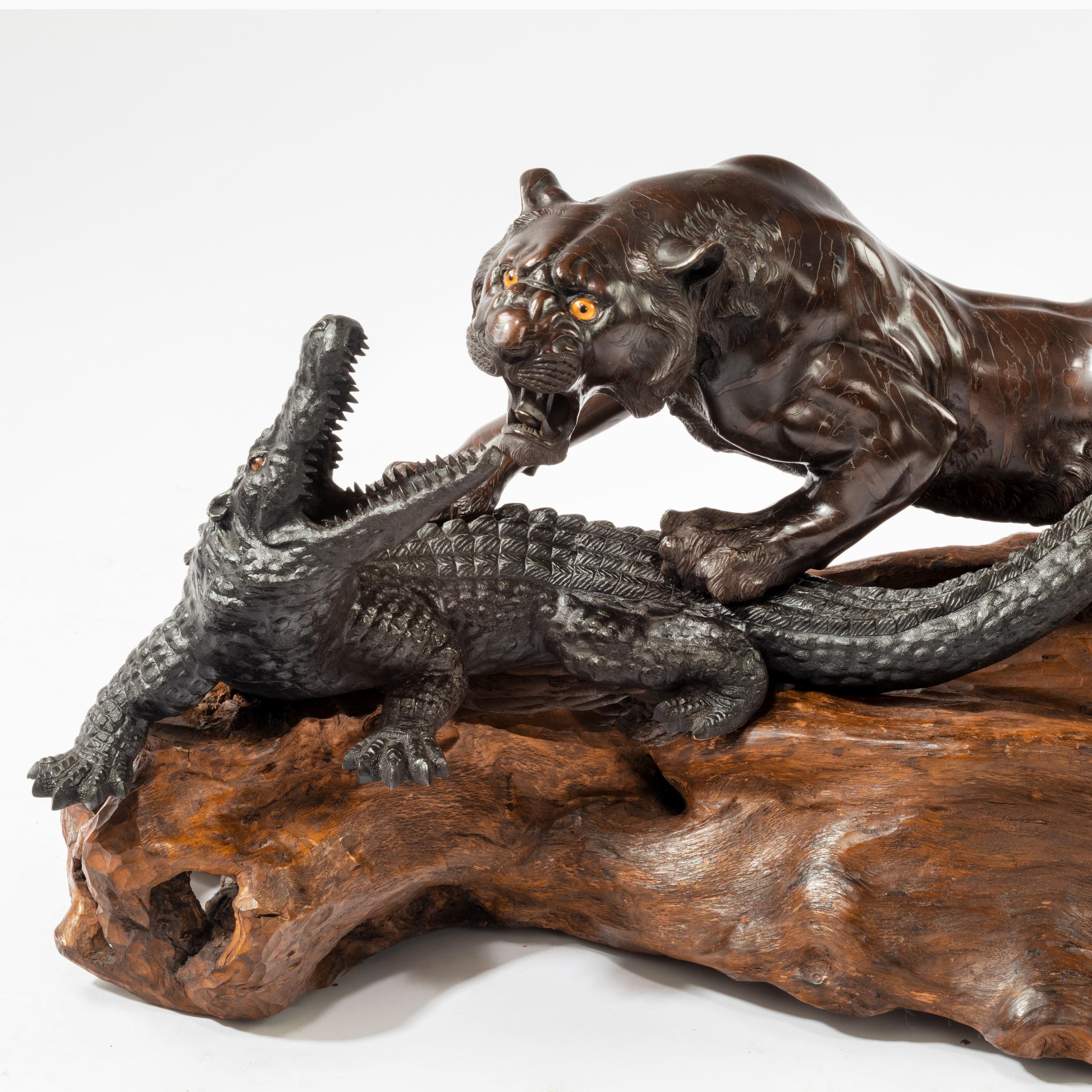 An unusual Meiji period bronze of a tiger and an alligator by Genryusai Seiya, the creatures modelled separately with the tiger attempting to pin down the snapping alligator, the pelt of the tiger and the characteristic skin of the reptile