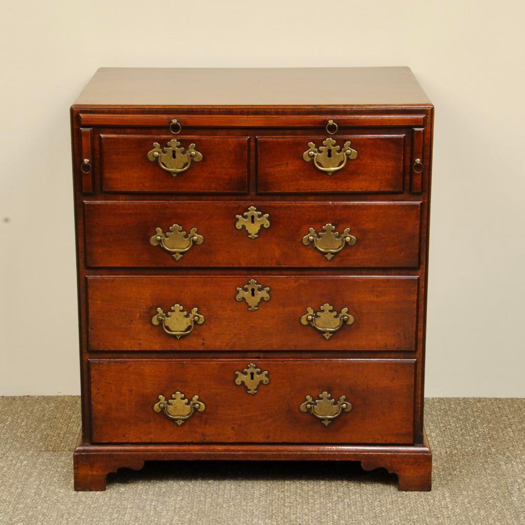 A super mid-18th century mahogany chest of graduated drawers, two over three. Fantastic original handles and the unusual design having lopers for the brushing slide, great color and patina.