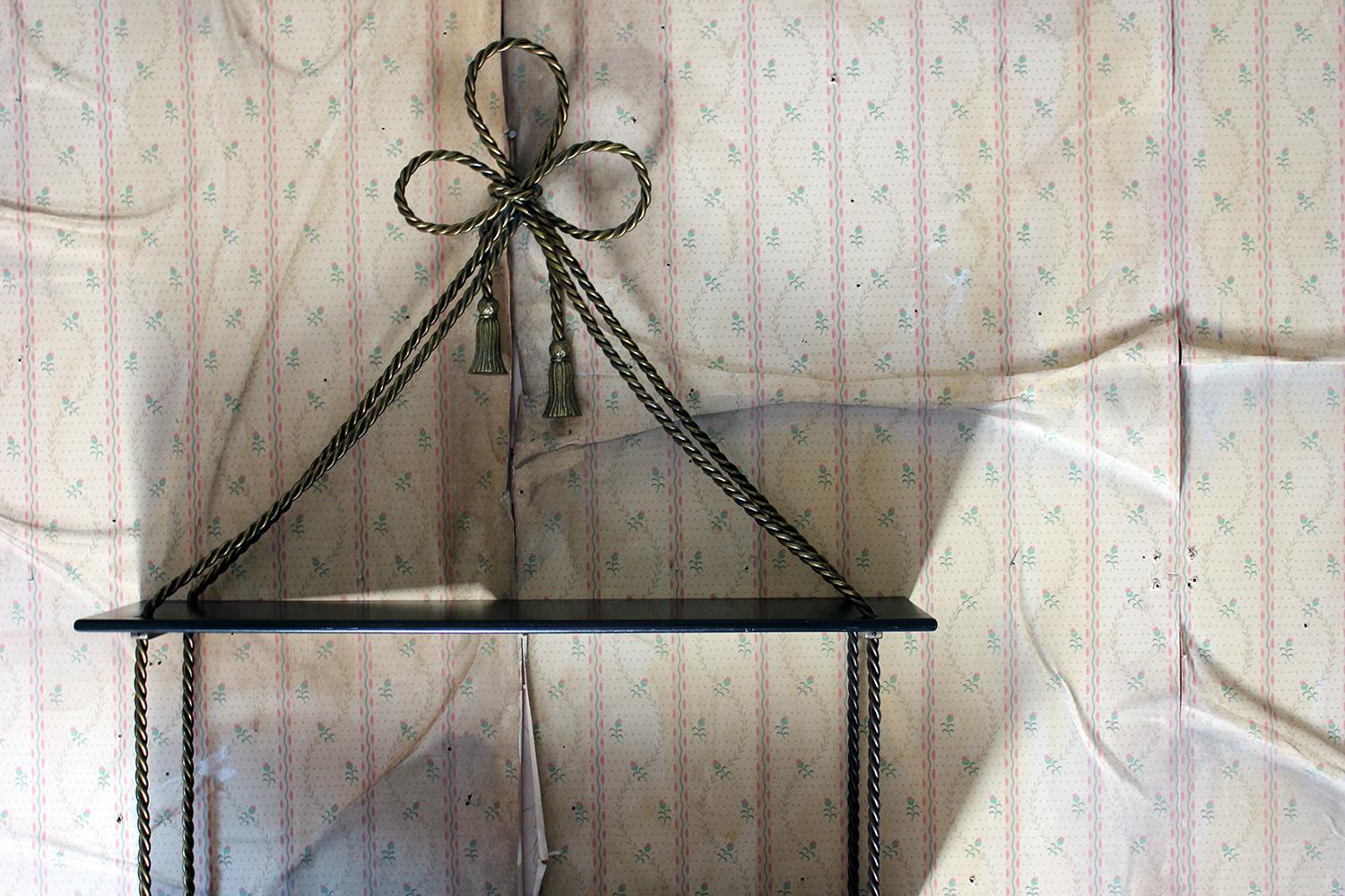The ebonized and gilt-metal wall shelf having three tiers united by tasseled rope twist supports and terminating in a tied bow, the whole surviving from midcentury, England.

The shelving is in good stable and useable condition with no damages to