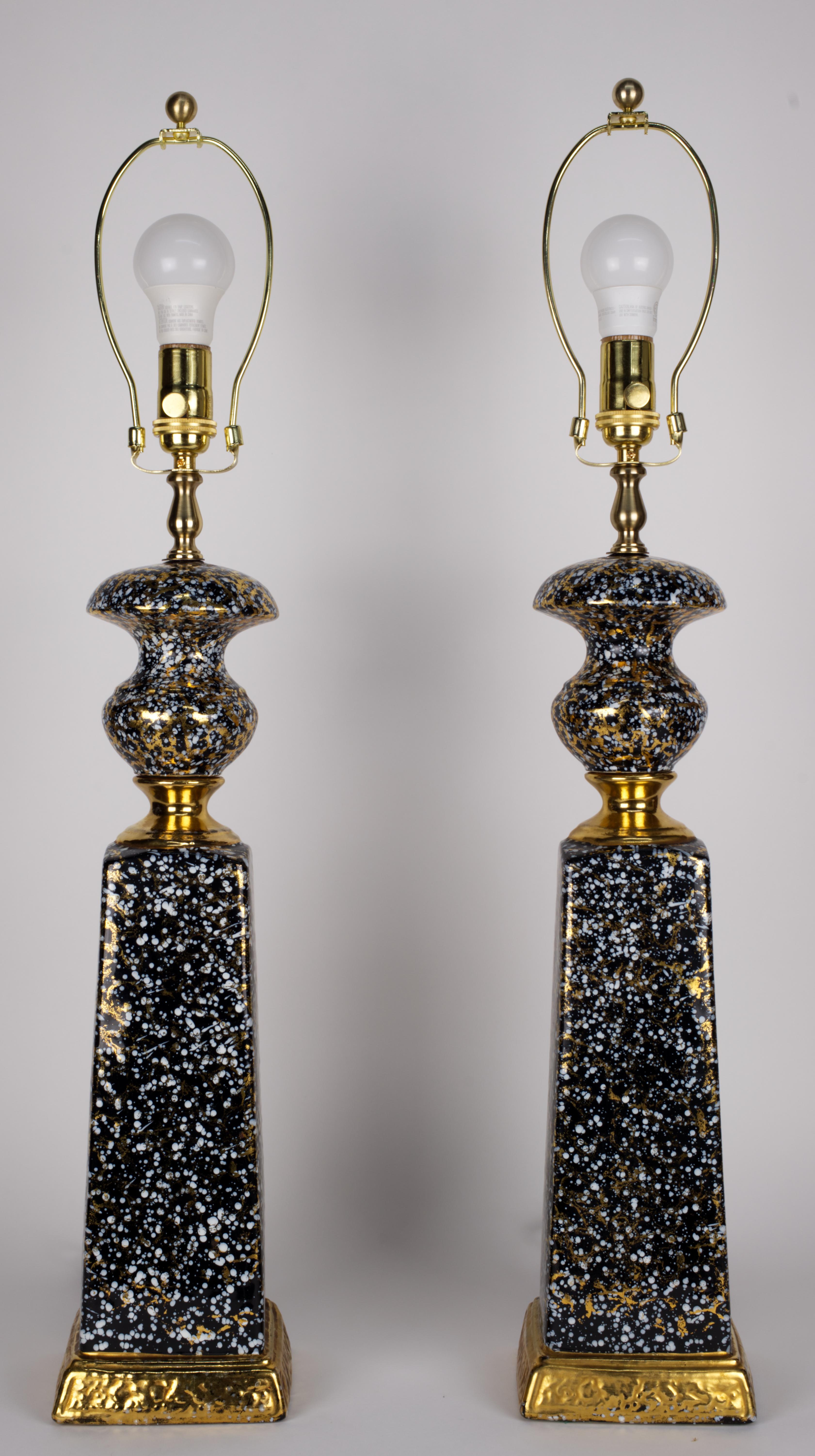 Paire de lampes de table inhabituelles en céramique Modern-Decor, décorées d'éclaboussures graphiques or et blanches sur fond noir. Les bases et les parties centrales des lampes sont accentuées par de larges bordures dorées.

Les lampes mesurent