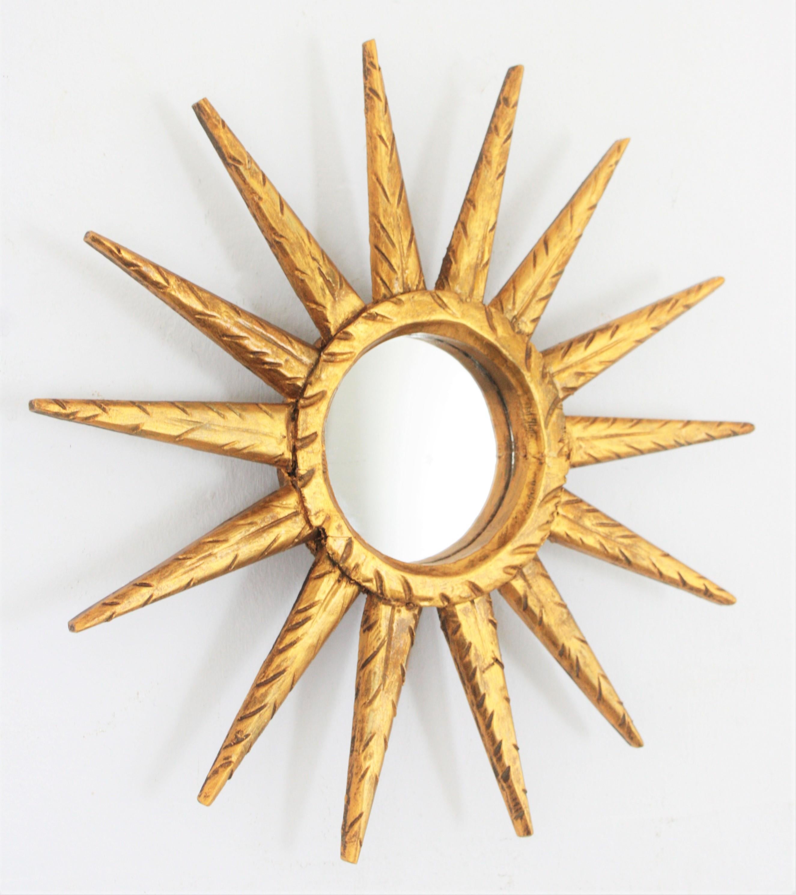 Lovely small giltwood starburst mirror with carved details. Lovely to place with other miniature mirrors or sunburst mirrors, Spain, 1960s.
Glass dimensions: 9cm diameter.
 