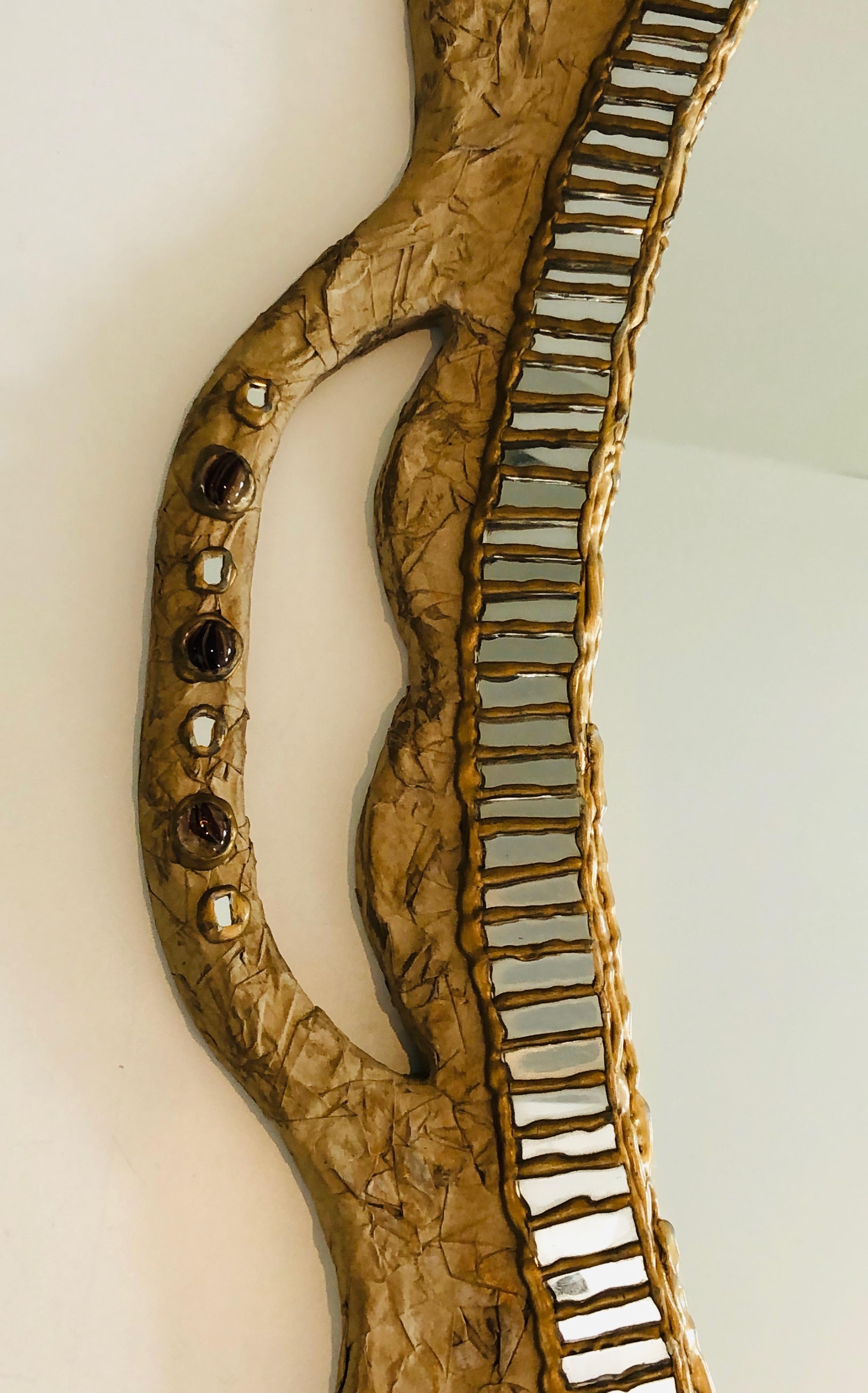 Questo insolito specchio è realizzato in cartapesta e intarsio di specchi e incrostazioni. Si tratta di un'opera francese, firmata da A. David. Circa 1970