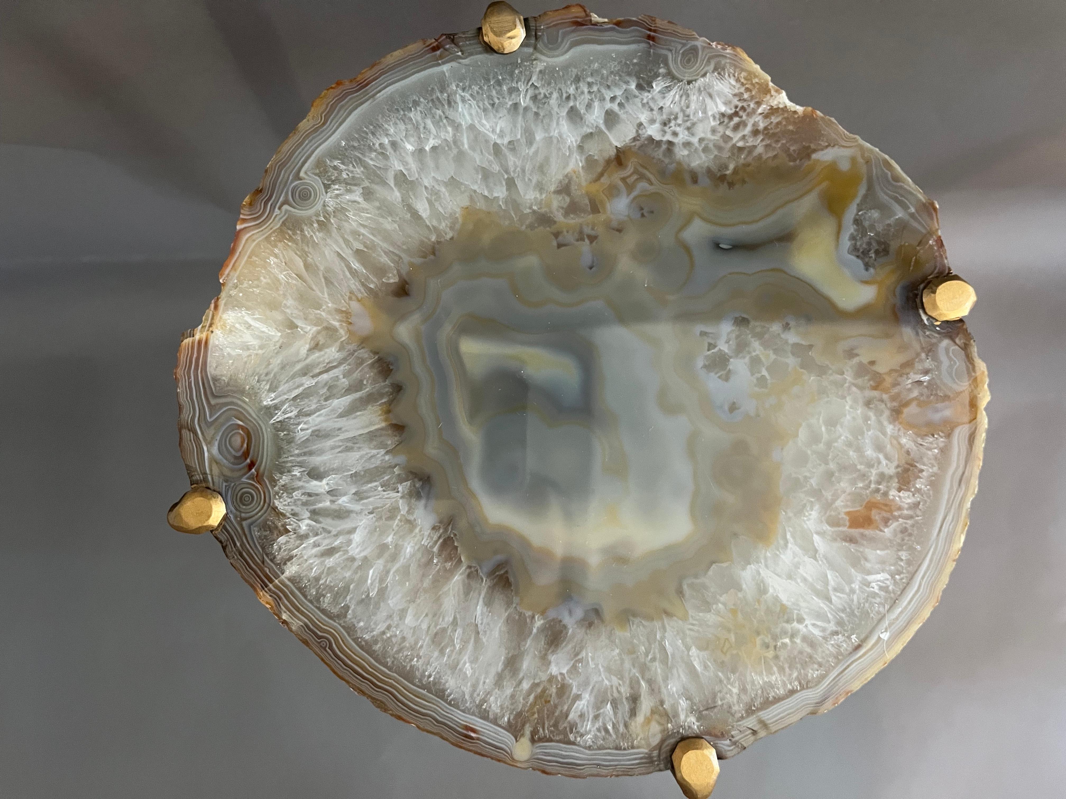 Our Geode Tables are crafted using one of a kind quartzite slabs, polished and set into a modern steel base. The depth of tone within the geode, when near a light source is captivating.  Handcrafted with one of a kind quartzite slabs and gold gilt