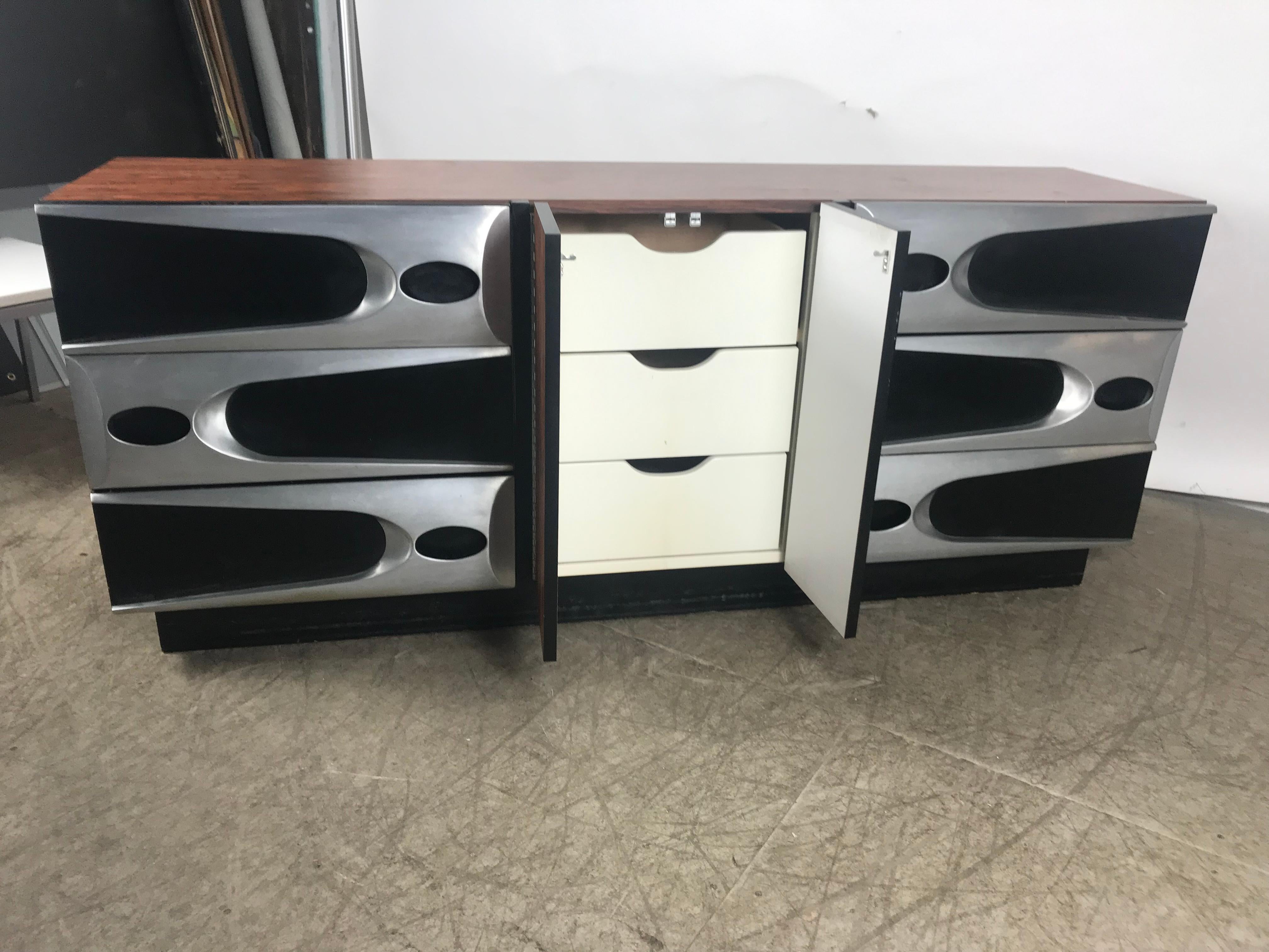Modernist. Space age 9-drawer dresser. Elegance blended with Space Age design, most unusual!!! Rosewood melamine (laminate) and aluminum, dated 1974. Three drawers on left. Three drawers on right, center hinged door with three drawers behind. Hand