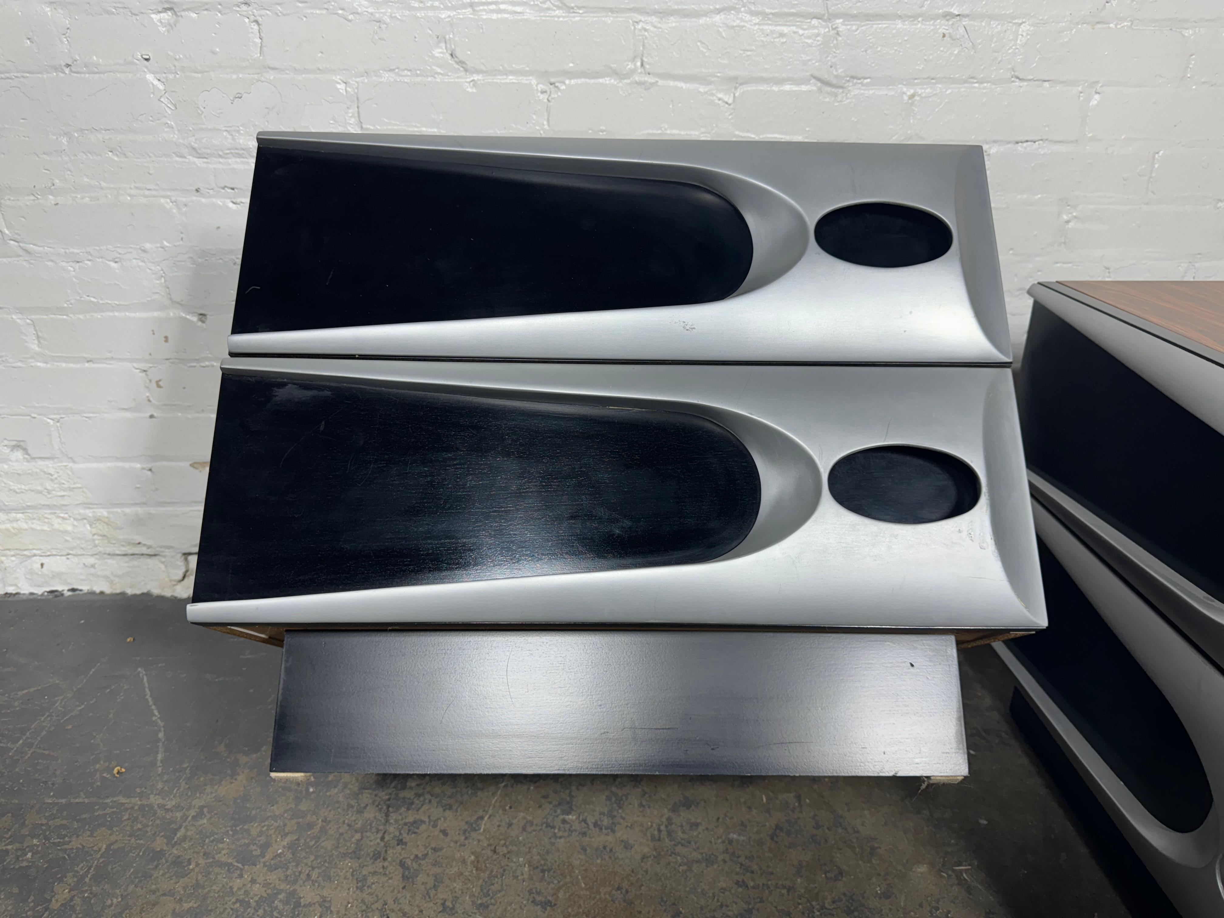 Unusual Modernist Space Age Nightstands, Melamine Rosewood and Aluminum.Elegance blended with Space Age design.Most unusual rosewood melamine laminate and aluminum. Pair 2-drawer nightstands. Hand delivery avail to nEW yORK cITY OR ANYWHERE EN ROUTE
