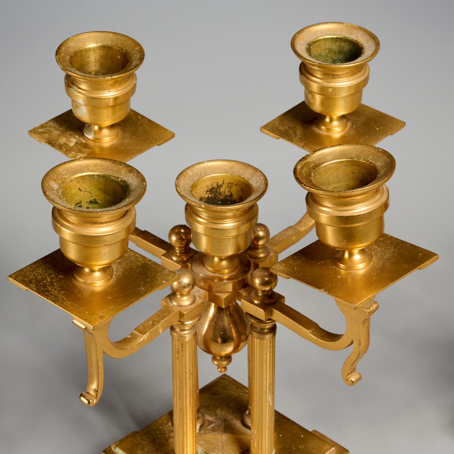 Fine del XIX secolo, Francia, coppia di candelabri Napoleone III in bronzo dorato e champlevé. Quattro supporti di colonna neoclassici sono sormontati da cinque coppe per candele, su un basamento decorato a smalto. Entrambi sono privi di segni di