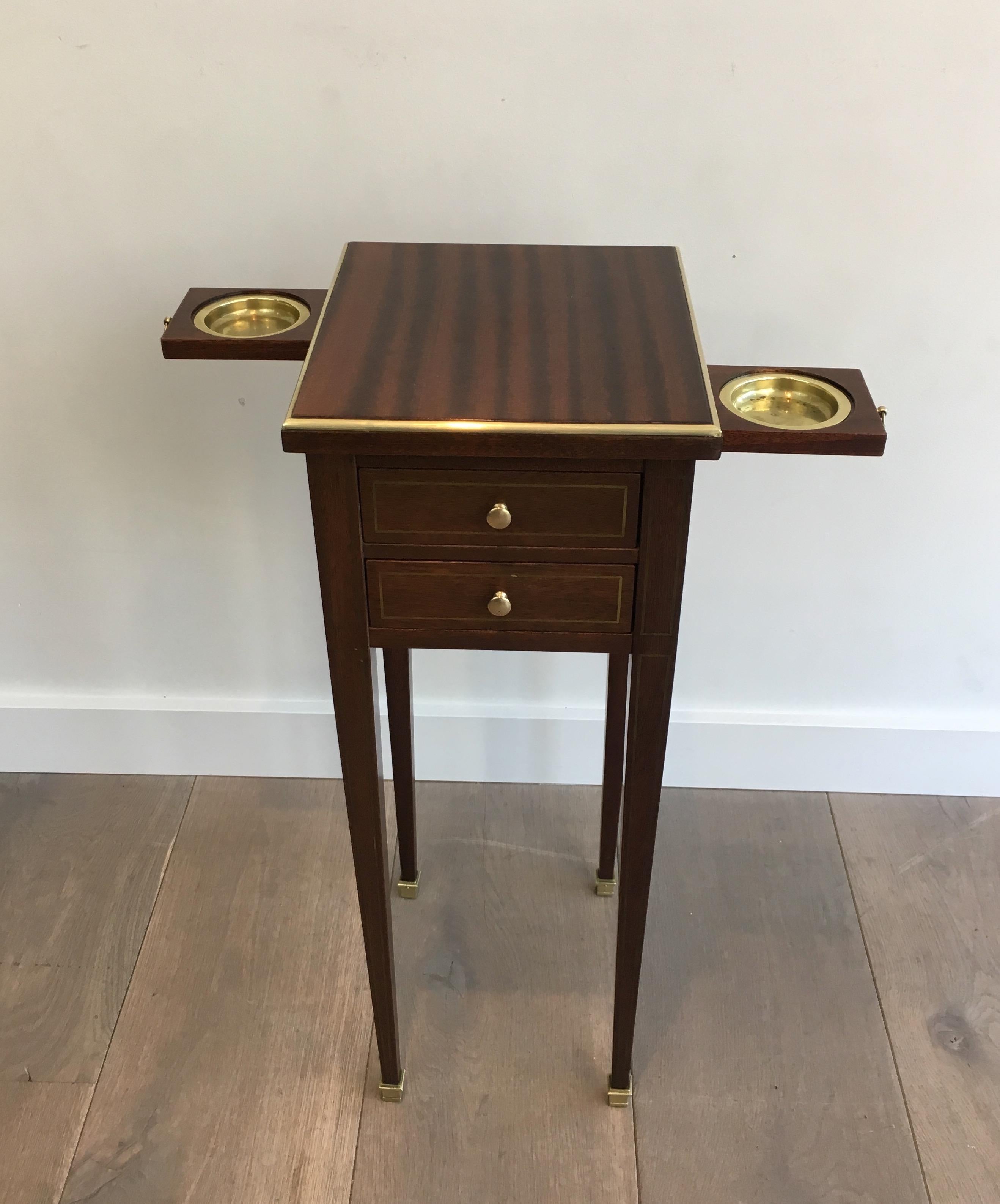 This rare and unusual neoclassical small drawers table is made of mahogany and brass. It has small sliding ashtrays on each side. This is a French work, in the style of famous French design Maison Jansen, circa 1940.