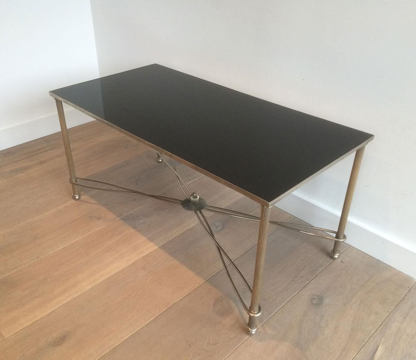 This unusual coffee table is made of nickel with a nice stretcher and a black lacquered glass shelf. This is a French work, circa 1960.