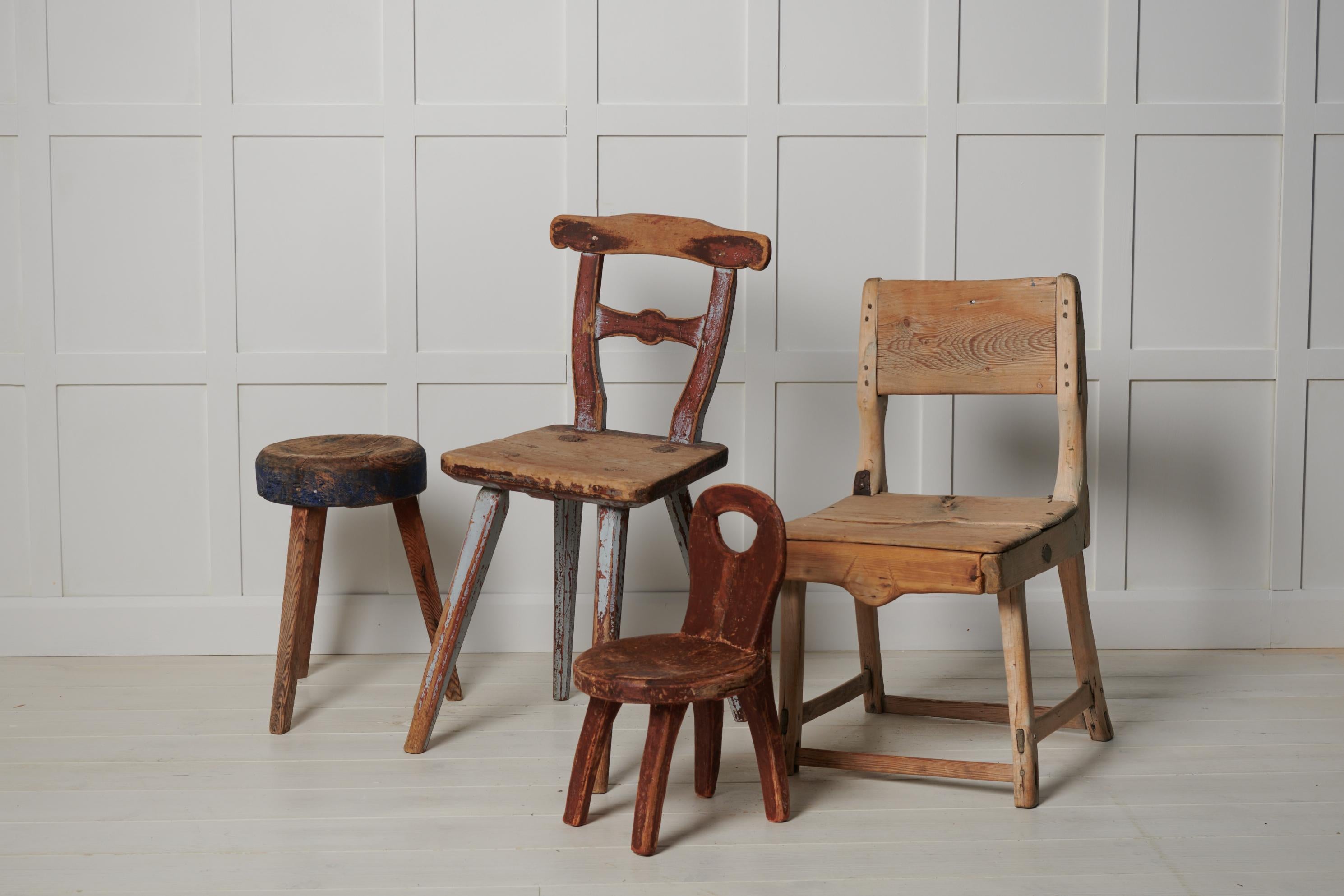 Ungewöhnlicher primitiver Bauernstuhl in Volkskunst aus Nordschweden. Der Stuhl ist ein Einzelstück, das um 1820 bis 1840 aus massivem Kiefernholz handgefertigt wurde. Alte historische Farbe, die durch den Gebrauch in Mitleidenschaft gezogen wurde.