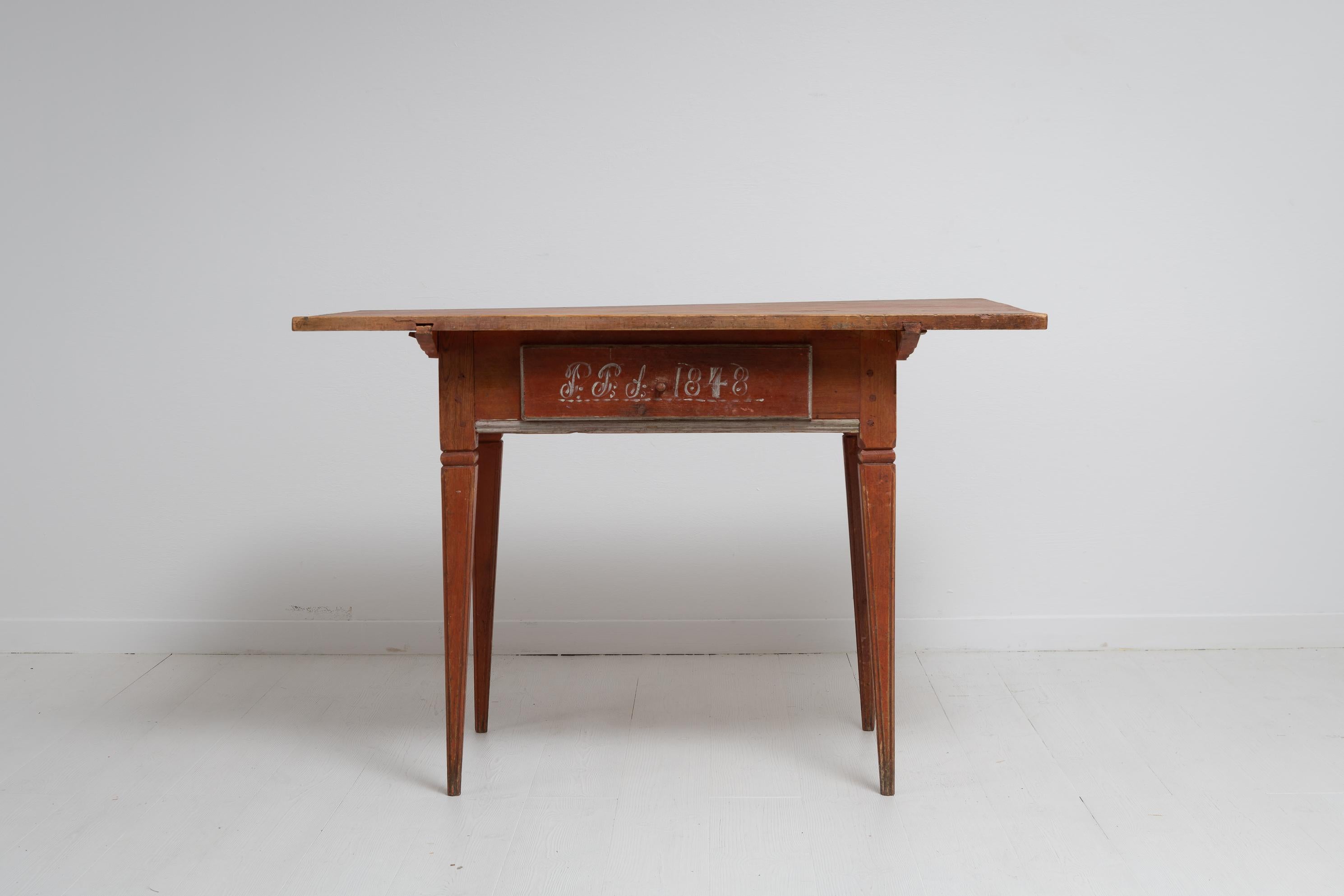 Nordschwedischer Tisch aus Kiefer im gustavianischen Stil. Der Tisch ist ein seltenes Exemplar und hat eine große Schublade in der Mitte und gerade, konische Beine mit Kanneluren. Handgefertigt und in echtem, unberührtem Zustand mit lachsfarbener