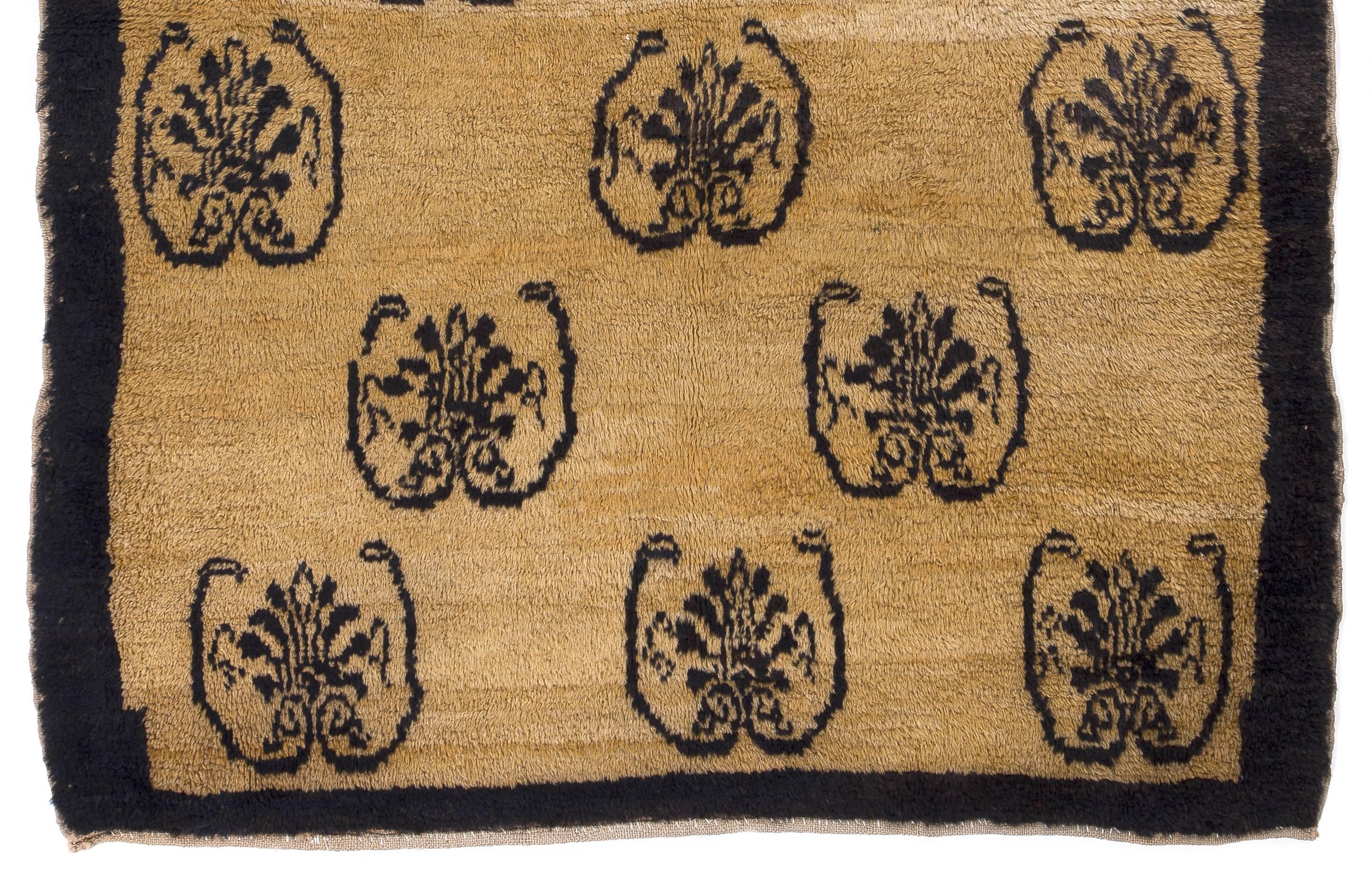 A unique central Anatolian rug from the village of Karapinar. Fascinating tribal design on a beautiful natural undyed camel ground framed with a dull navy blue border. The rug is made of sheep and camel wool blended with lustrous velvety angora