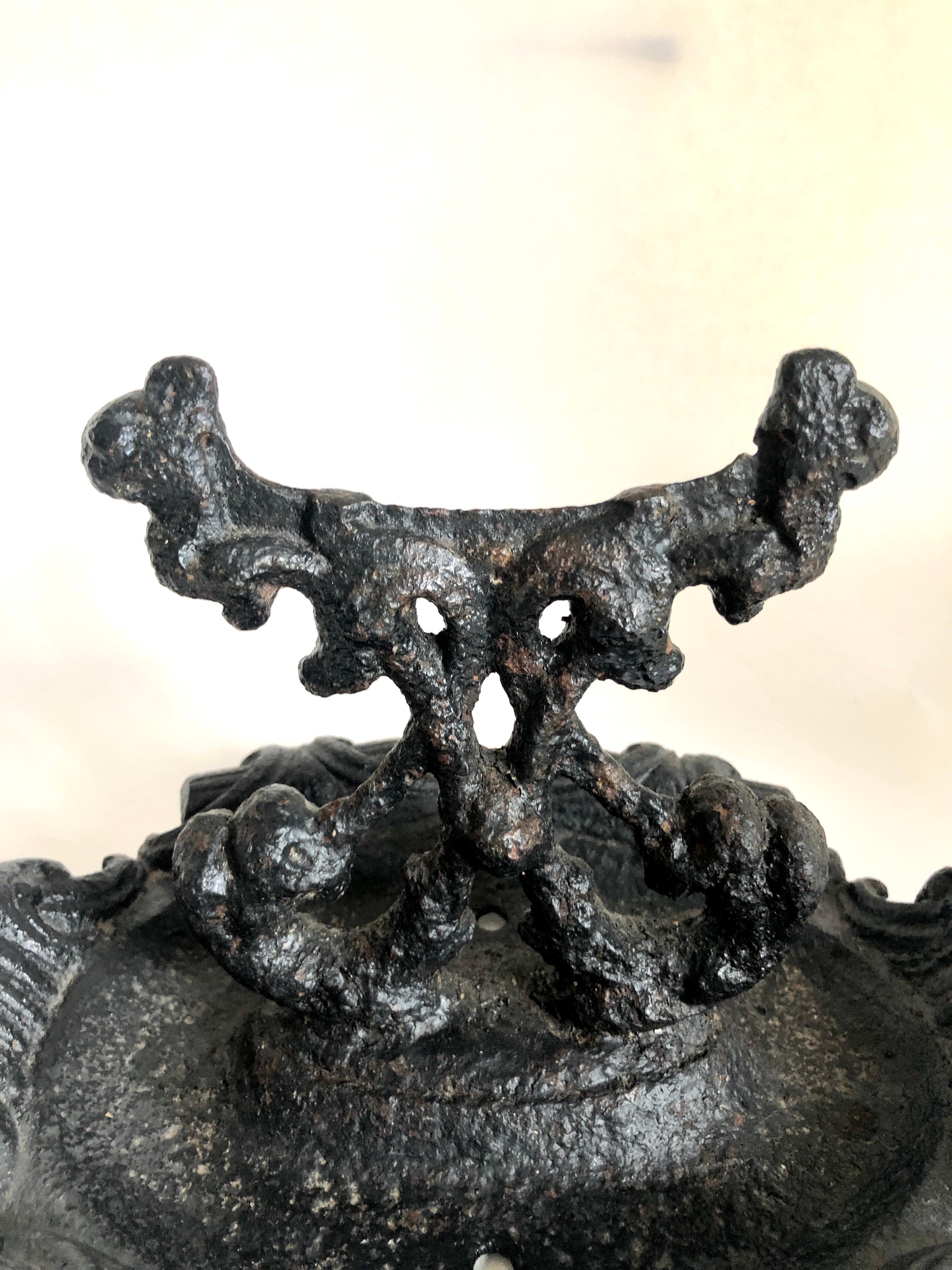 Unusual ornate cast iron foot scraper having an ornate cast iron base with scraper to the centre. 


   