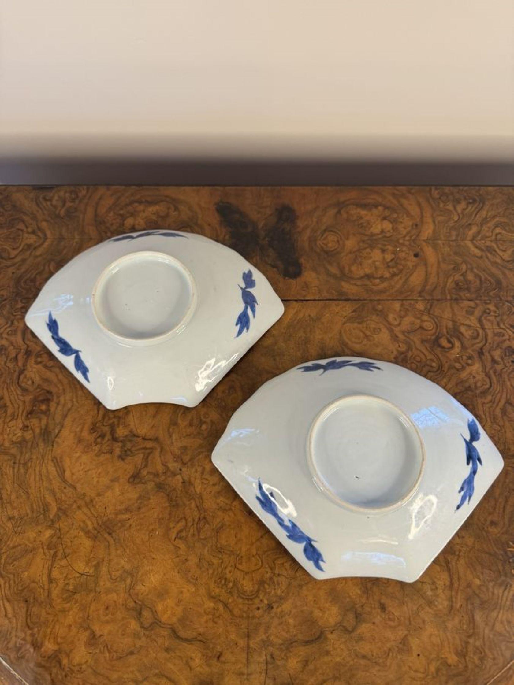 Unusual pair of antique blue and white fan shaped Japanese imari dishes, having an unusual pair of antique Japanese imari fan shaped dishes decorated with flowers, leaves and butterflies hand painted in beautiful blue and white colours.

D. 1900
