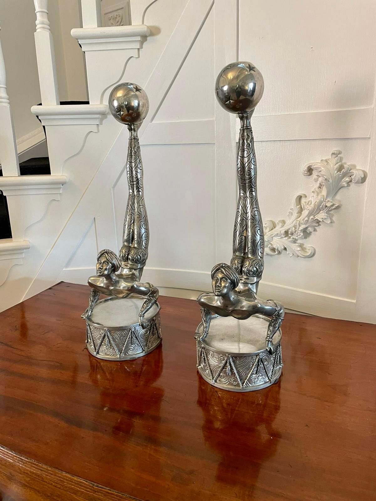 Insolita coppia di candelabri in argento Art Deco di qualità antica con un acrobata del circo che tiene in equilibrio un portacandele a forma di palla sui piedi e si regge su un tamburo decorato 

Un'affascinante coppia con un design splendido e