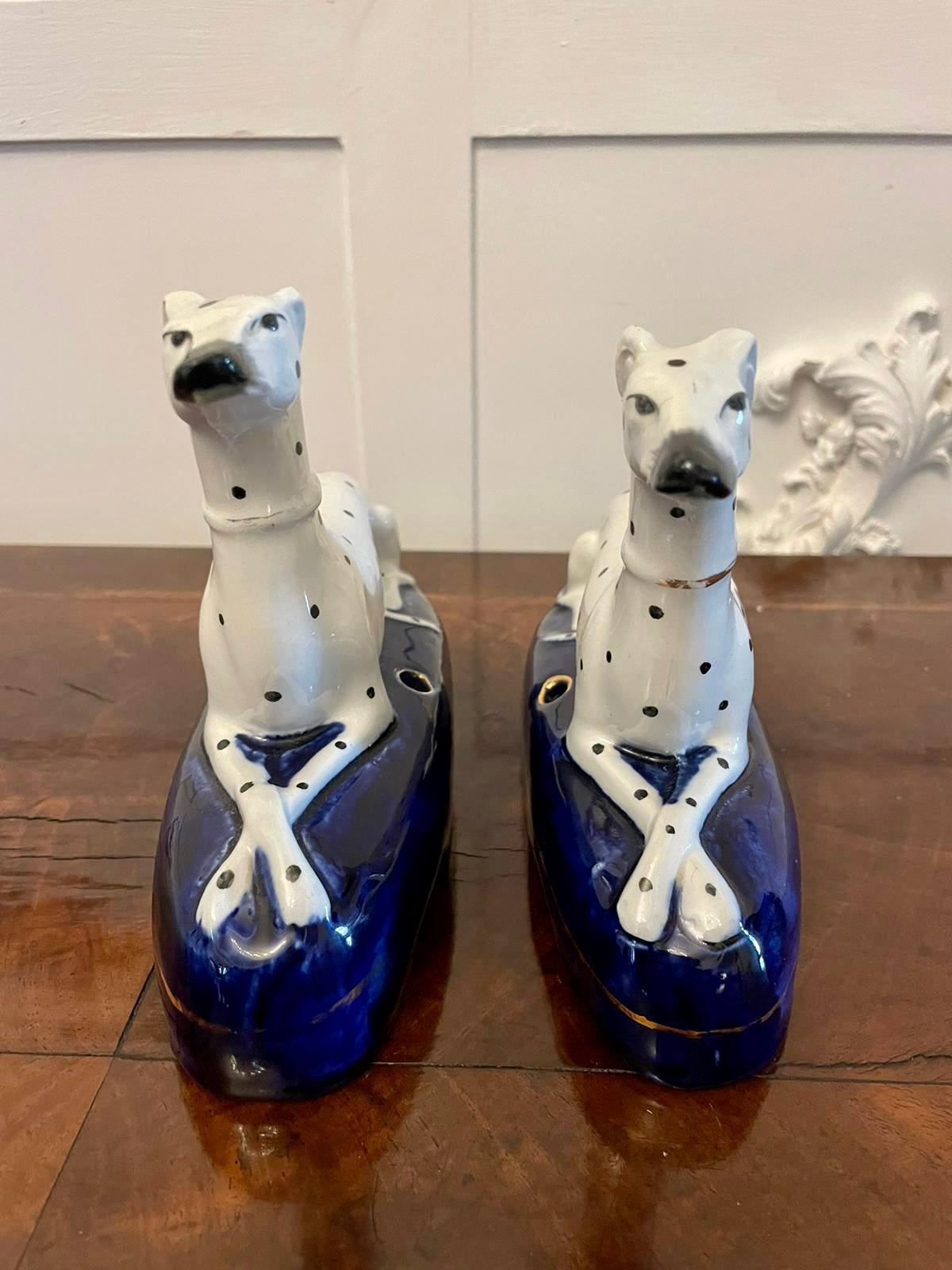 Unusual pair of antique Victorian quality Staffordshire inkwells of white and black spotted dogs on an oval blue base

An attractive pair in perfect original condition

H 14.5 x W 18 x D 6.5cm
Date 1860.
 