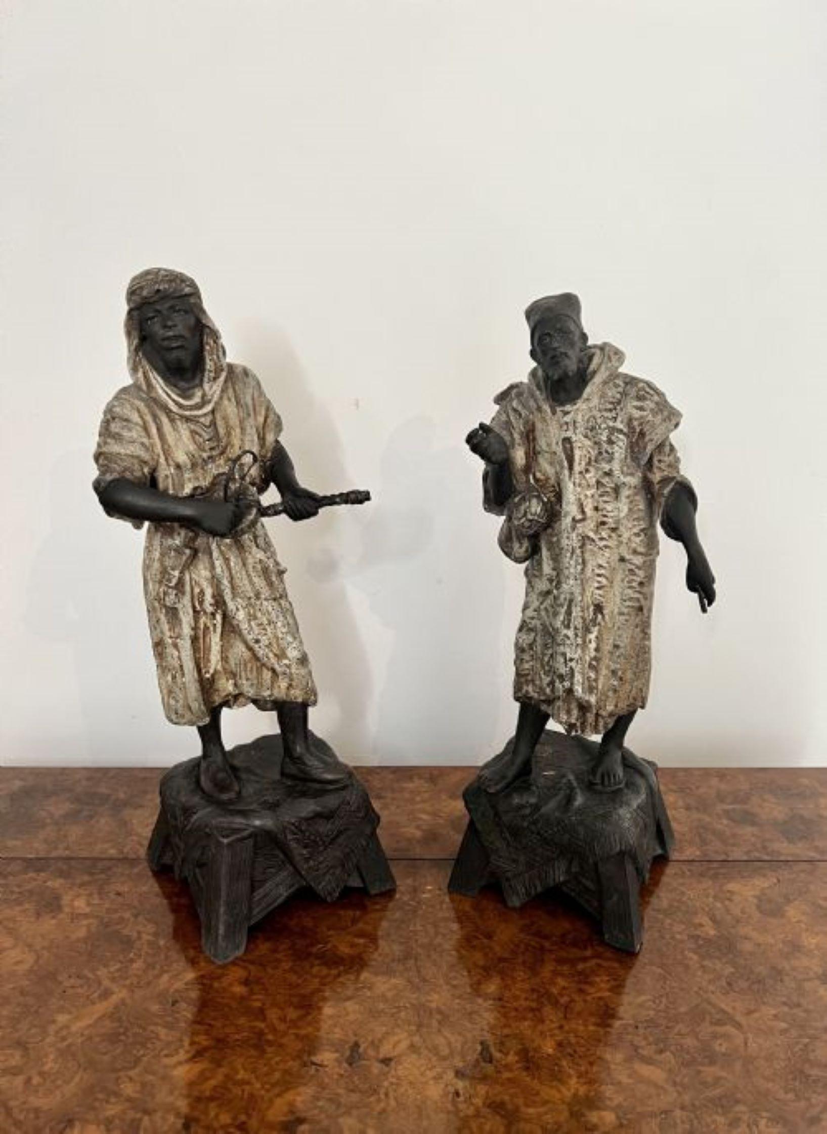 Unusual pair of antique Victorian spelter figures depicting two males in traditional moorish robes and headdresses standing on ornate square bases.