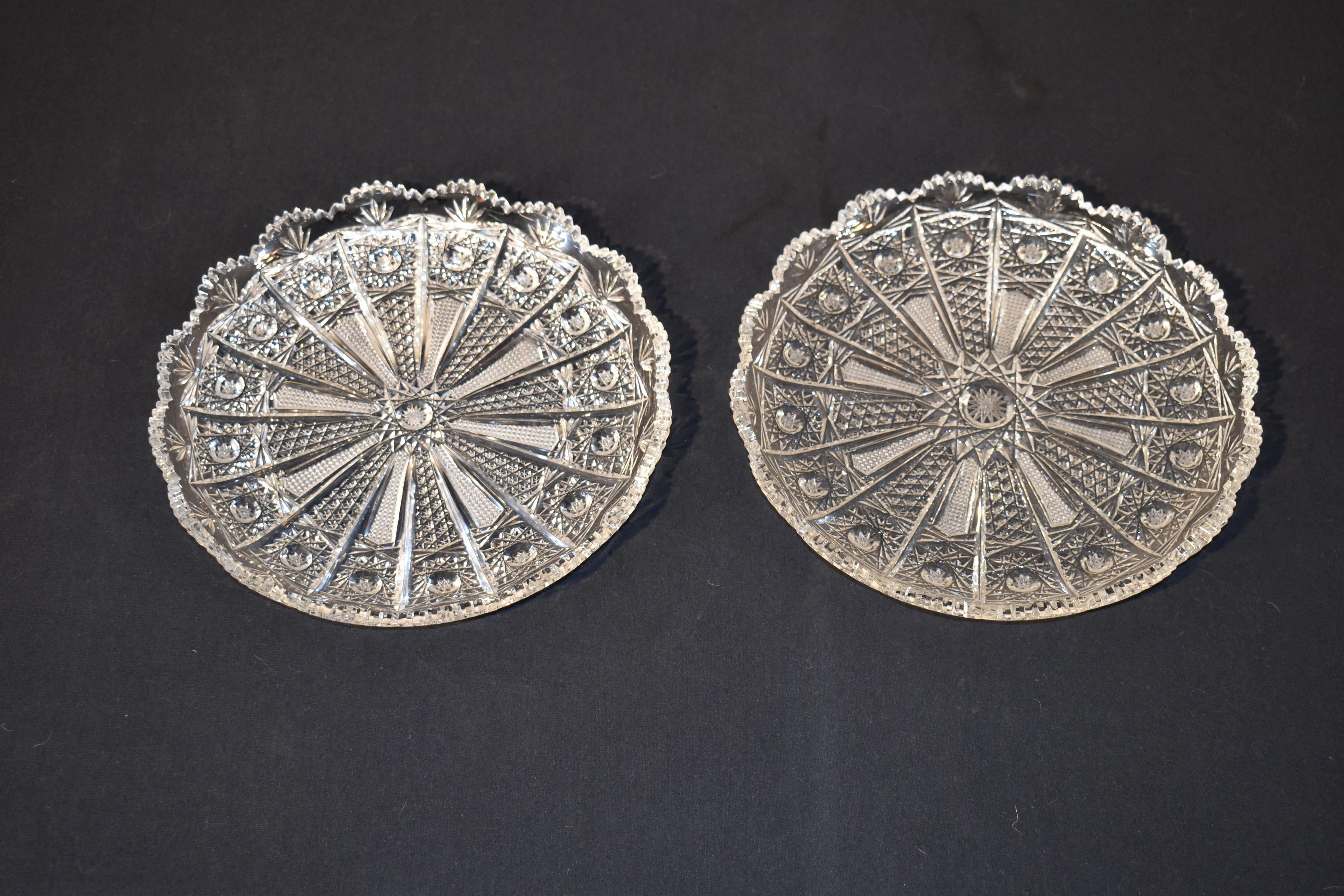 Unusual pair of large cut glass serving dishes, circa 1920's.  They have scalloped edges surrounding a wonderful pattern, almost like a fan with a central starburst design and similar design at the end of each 