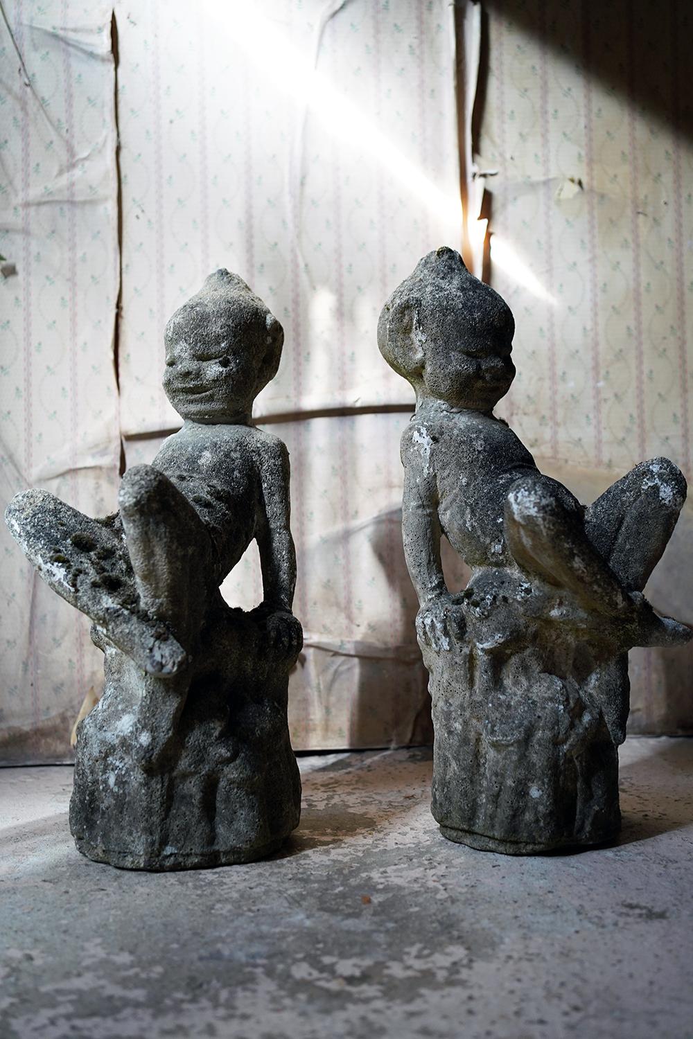 La rara e molto allegra coppia di folletti da giardino in pietra, ciascuno seduto a gambe incrociate su ceppi d'albero naturalistici con sorrisi maliziosi e cappelli e orecchie a punta, sopravvive dal secondo quarto del XX secolo.

I folletti sono