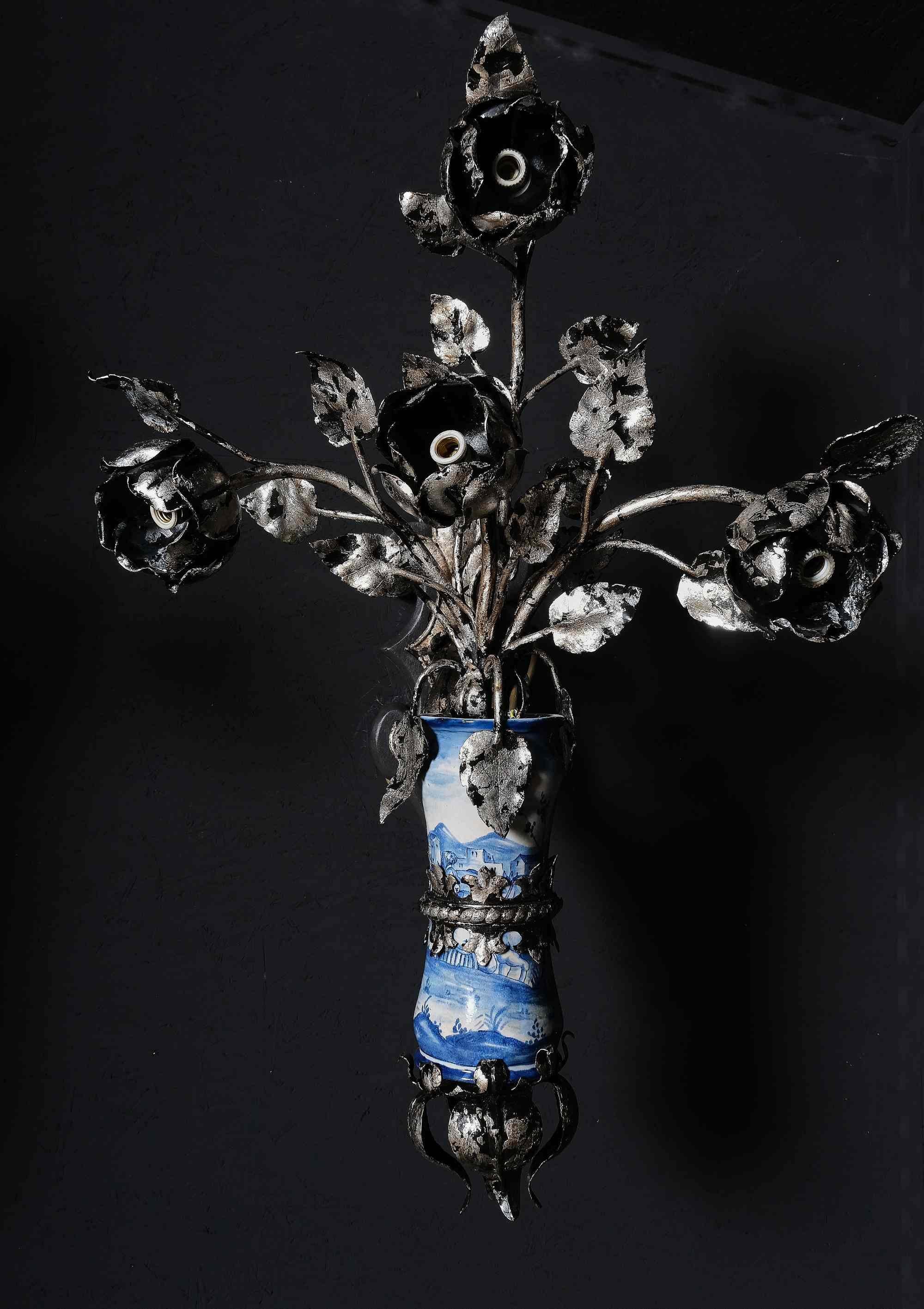Absolutely unusual pair of silvered and wrought iron sconces with inserted albarelli. The iron arms end with electrified rosebuds. The albarelli decorated with figures and landscapes, Naples 18th century. Wooden wall strip. Italy, early 20th century.