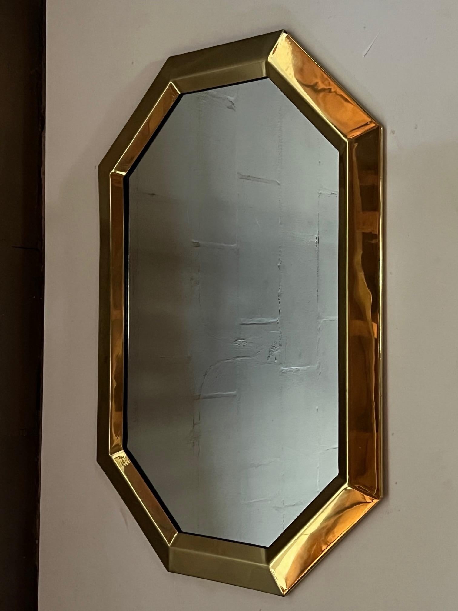 A 1970's polished brass mirror, shaped as an octagon, could be hung vertically or horizontally, well made and heavy.