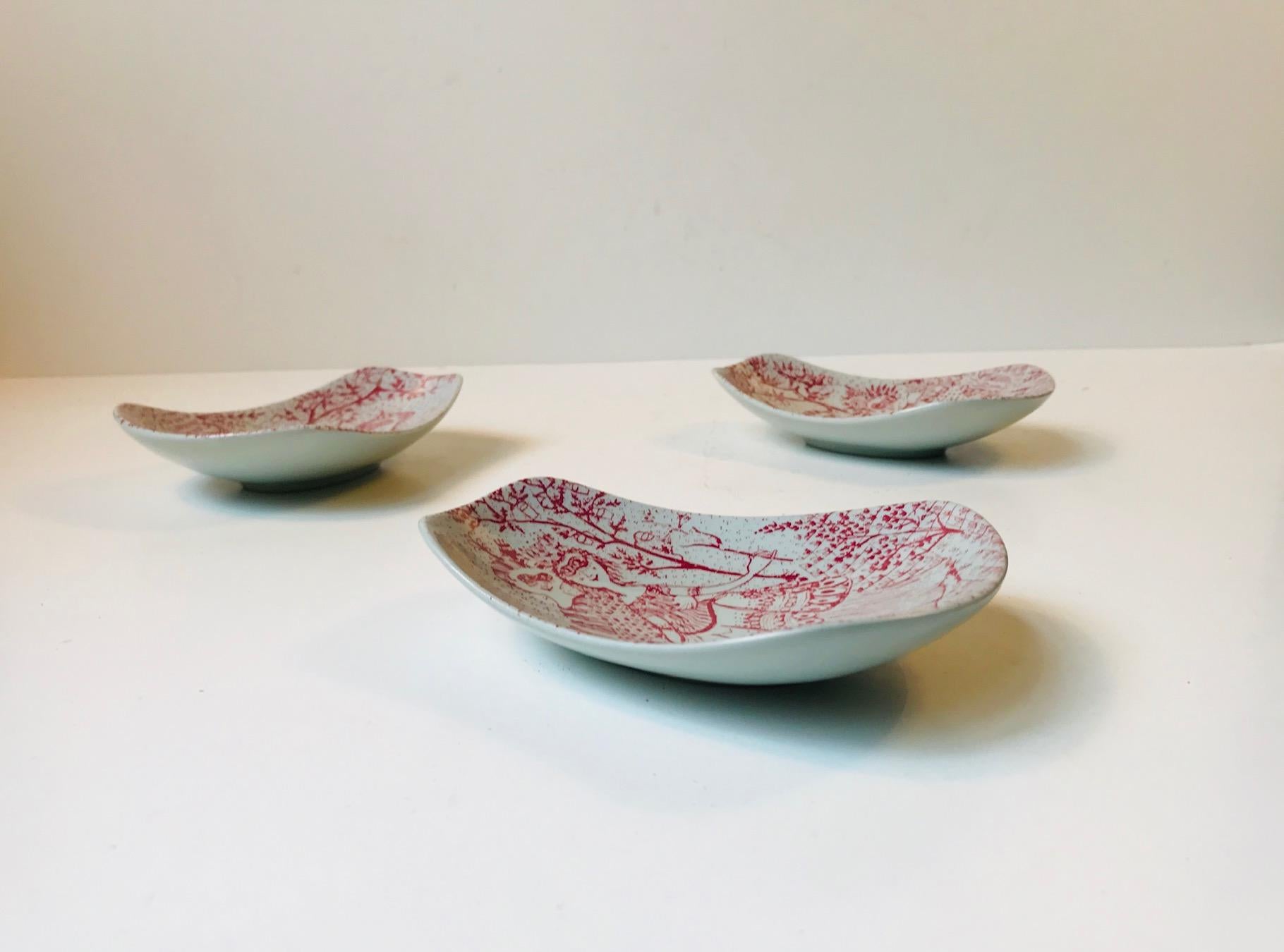 Lot of 3 rare tongue shaped bowls in the red line - design number 319-244. Designed by Bjorn Wiinblad and manufactured by Nymølle in Denmark during the 1970s. Each piece is signed W by hand and has the makers marks from Nymølle. Suitable for vanity