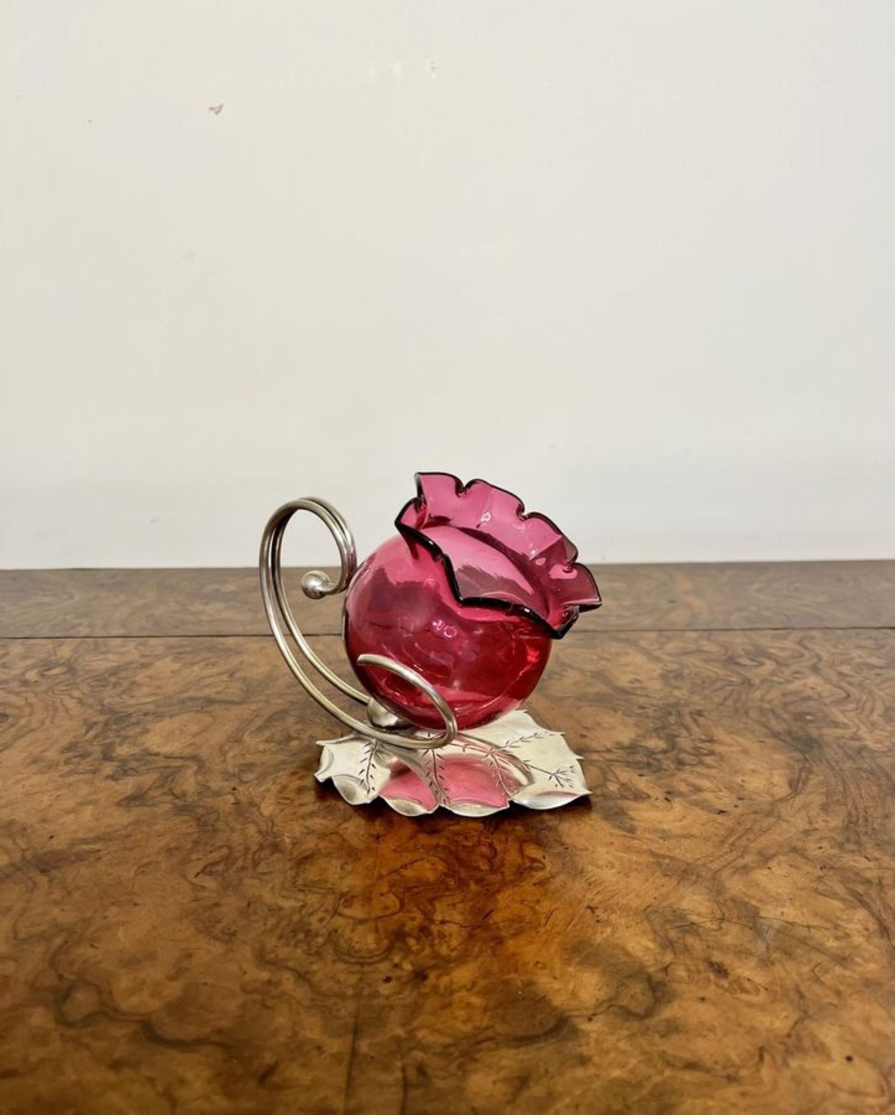 Unusual quality antique Edwardian cranberry glass candle holder having a silver plated stand in the shape of a leaf, a cranberry glass removable candle holder with a shaped handle to the back.

D. 1900