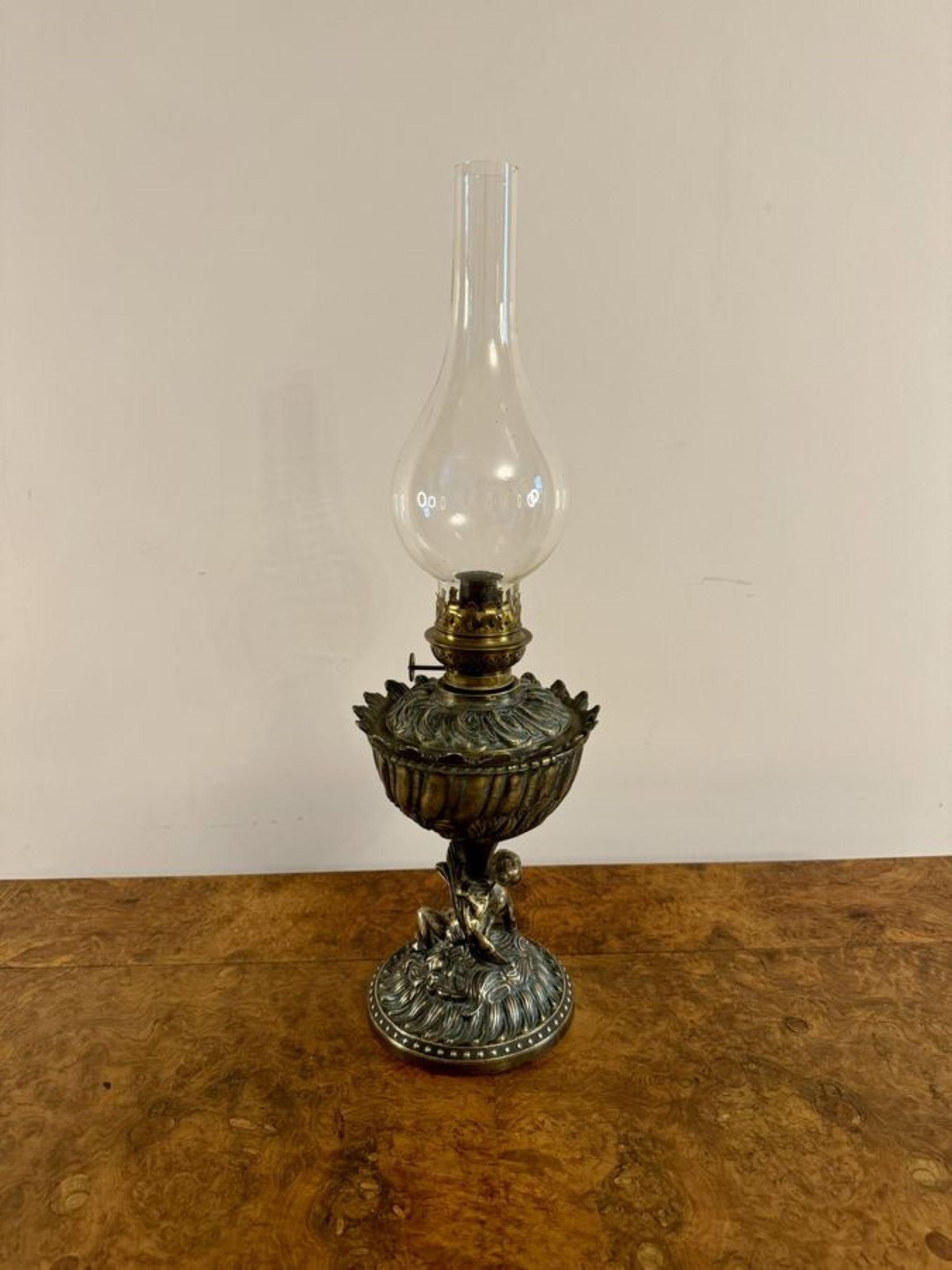 Unusual quality antique Victorian oil lamp having a quality antique Victorian oil lamp with a bulbous glass chimney, a single burner, a reeded column with wonderful scroll decoration, having a cherub mounted above the circular base. 

D. 1880