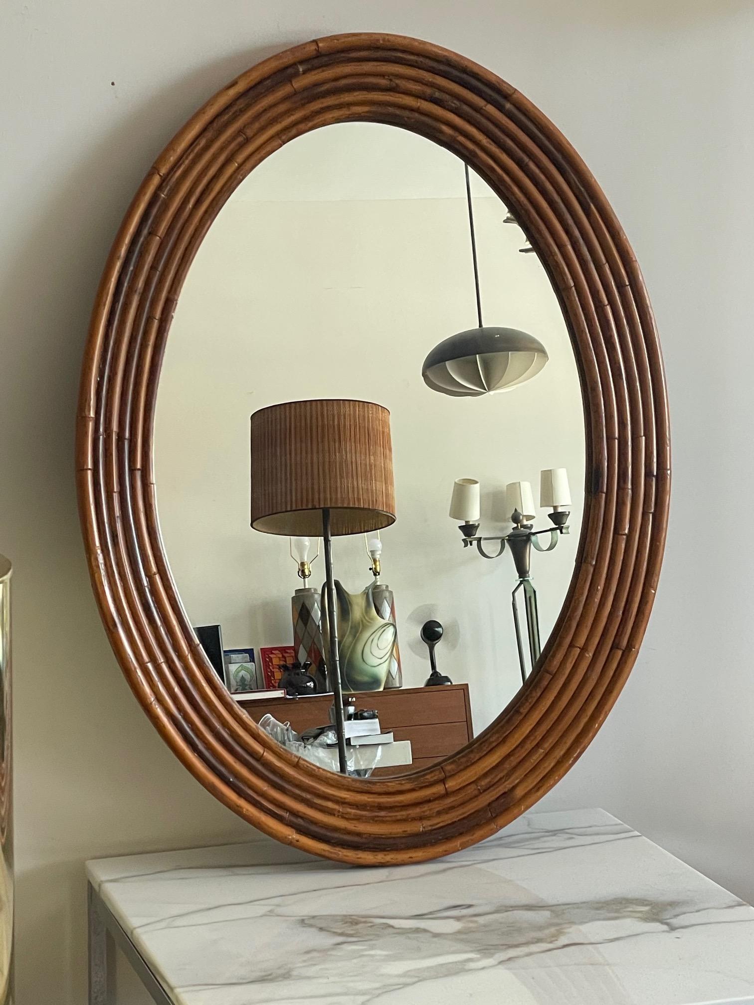 An unusual mirror made of six bands of rattan in front and three bands thick. Nice patina and character.