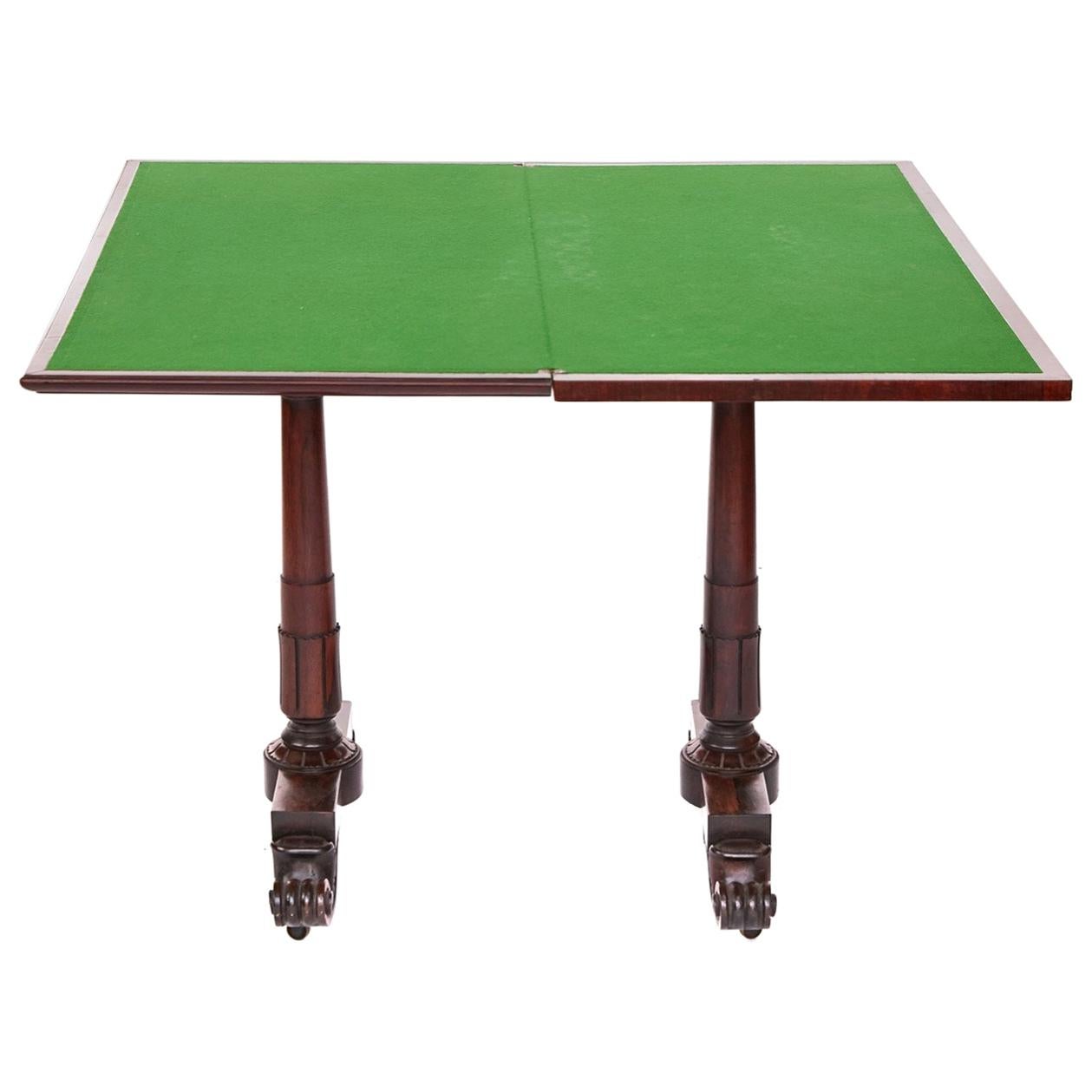 Unusual Regency hardwood card table having a lovely rosewood top standing on 2 pillar legs supported by lovely carved feet standing on original castors. Unusual action, as top folds back the end supports move to the middle, allowing for 4 people to