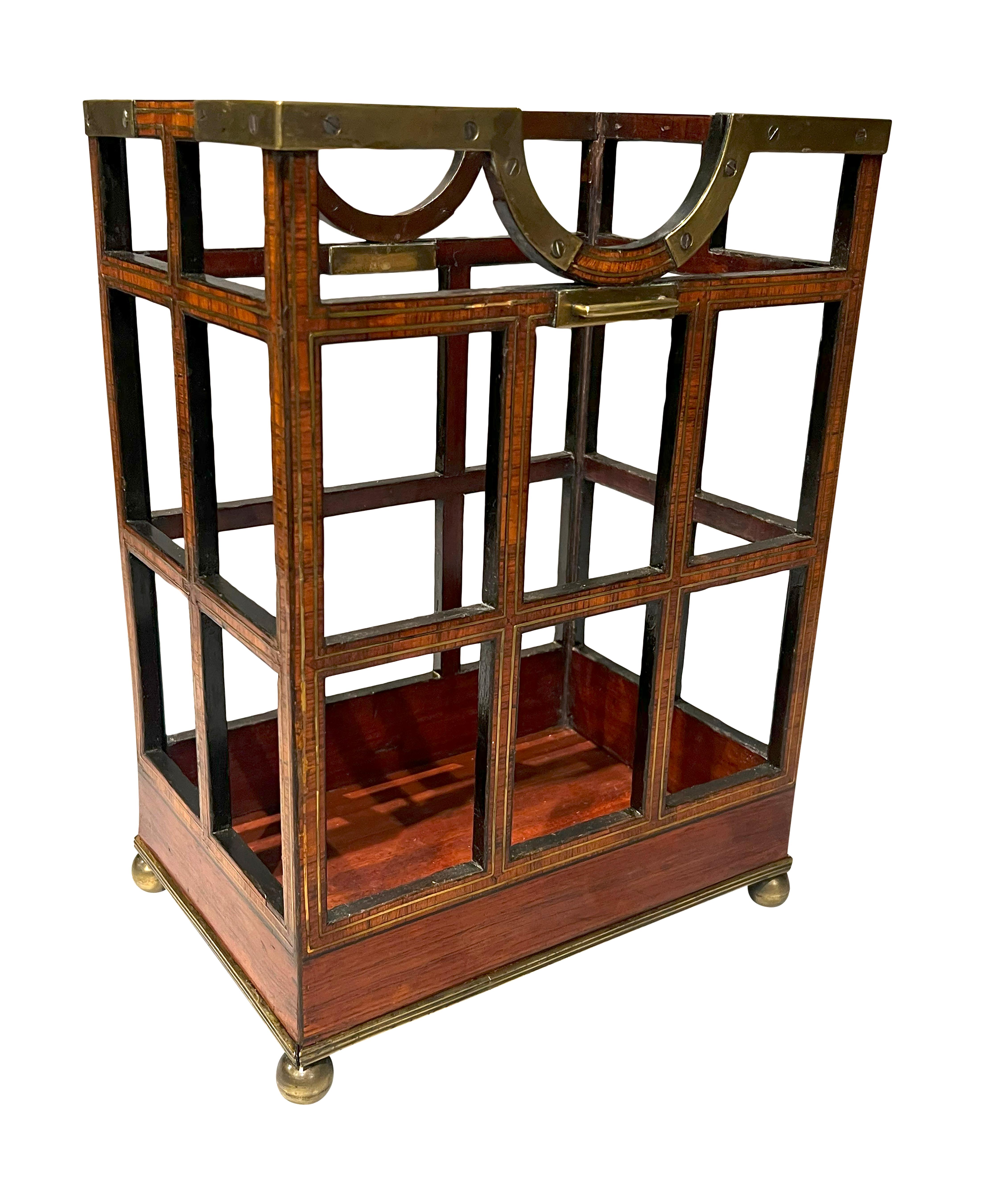 A unique piece with brass mountings of rectangular cage form with top recess to hold bottle. Lacking strap handle.Brass ball feet.