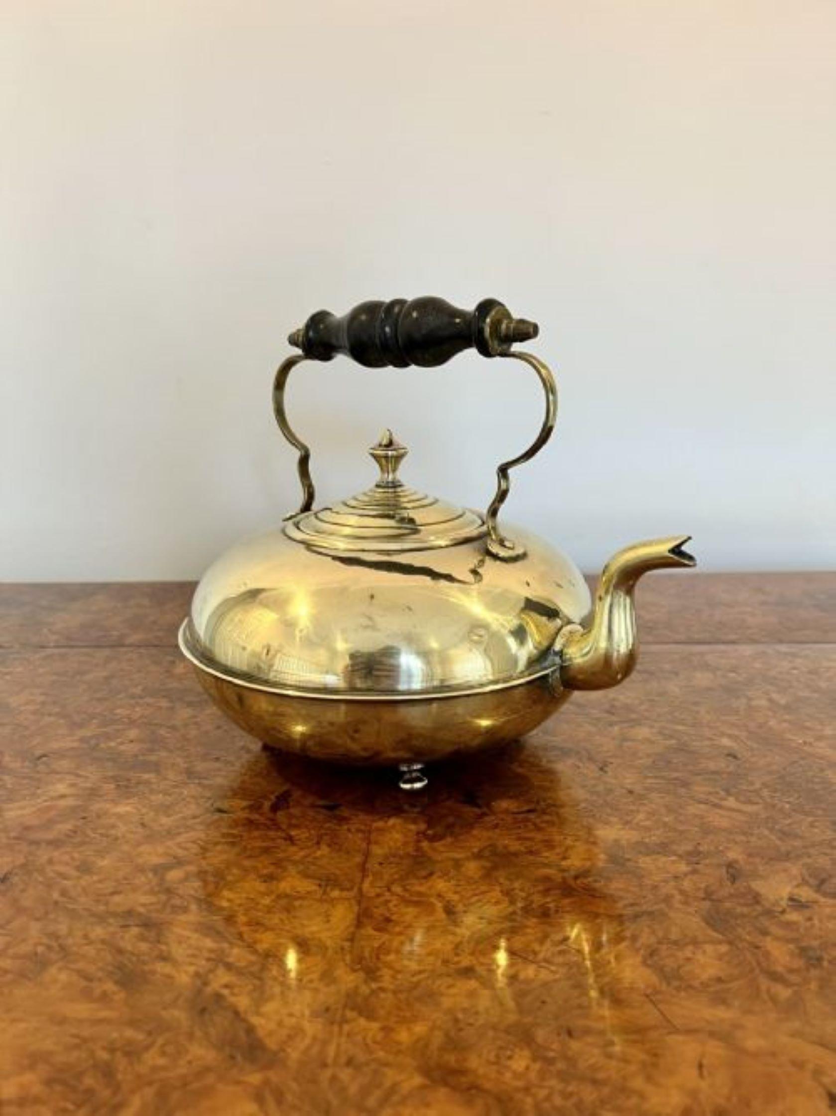 Unusual round antique Victorian quality brass kettle having a quality turned handle, shaped lift off lid standing on ball feet. 