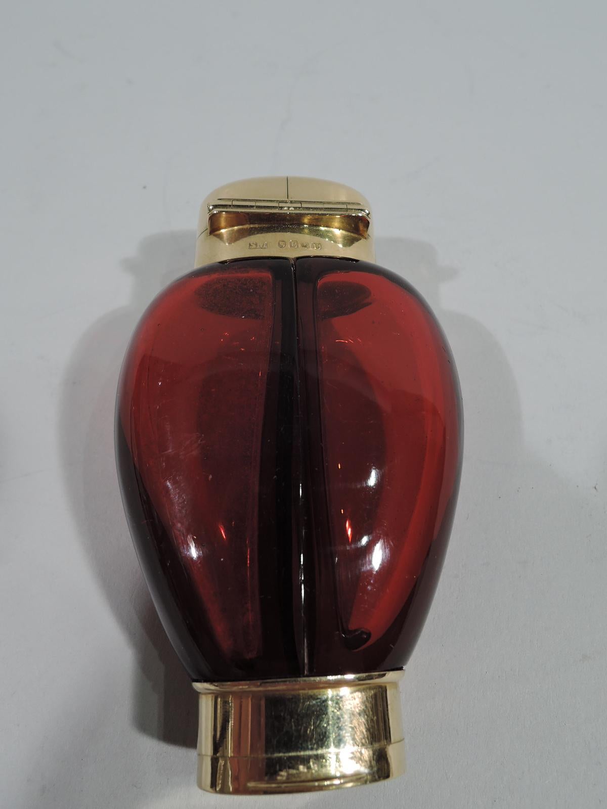Unusual ruby glass double perfume with 18K gold mounts. Made by Samson Mordan in Sheffield in 1869. Ovoid bottle comprising two parts with vertical join. Oval gold neck with hinged and split cover. Two clear glass stoppers with short plugs. On cover