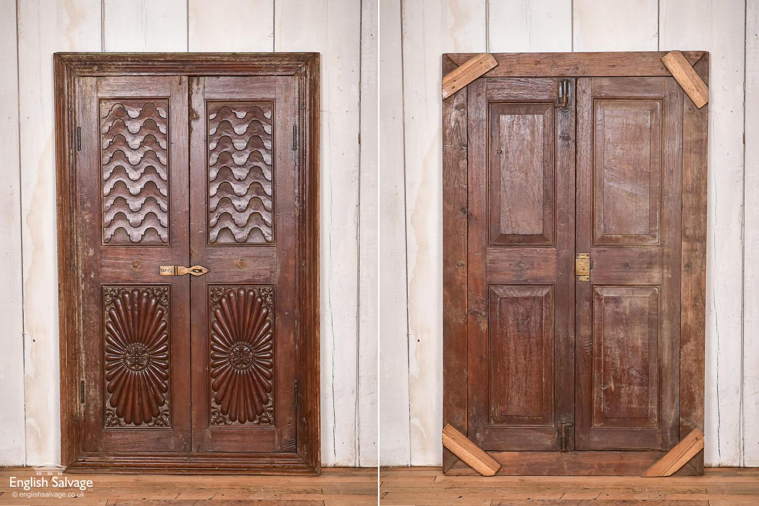 Lovely set of three antique carved teak wood window shutters, or could be used as cabinet or cupboard fronts. The shutters come in a moulded frame, with brass hinges and hardware. The front of the panels are carved at the top with a pattern
