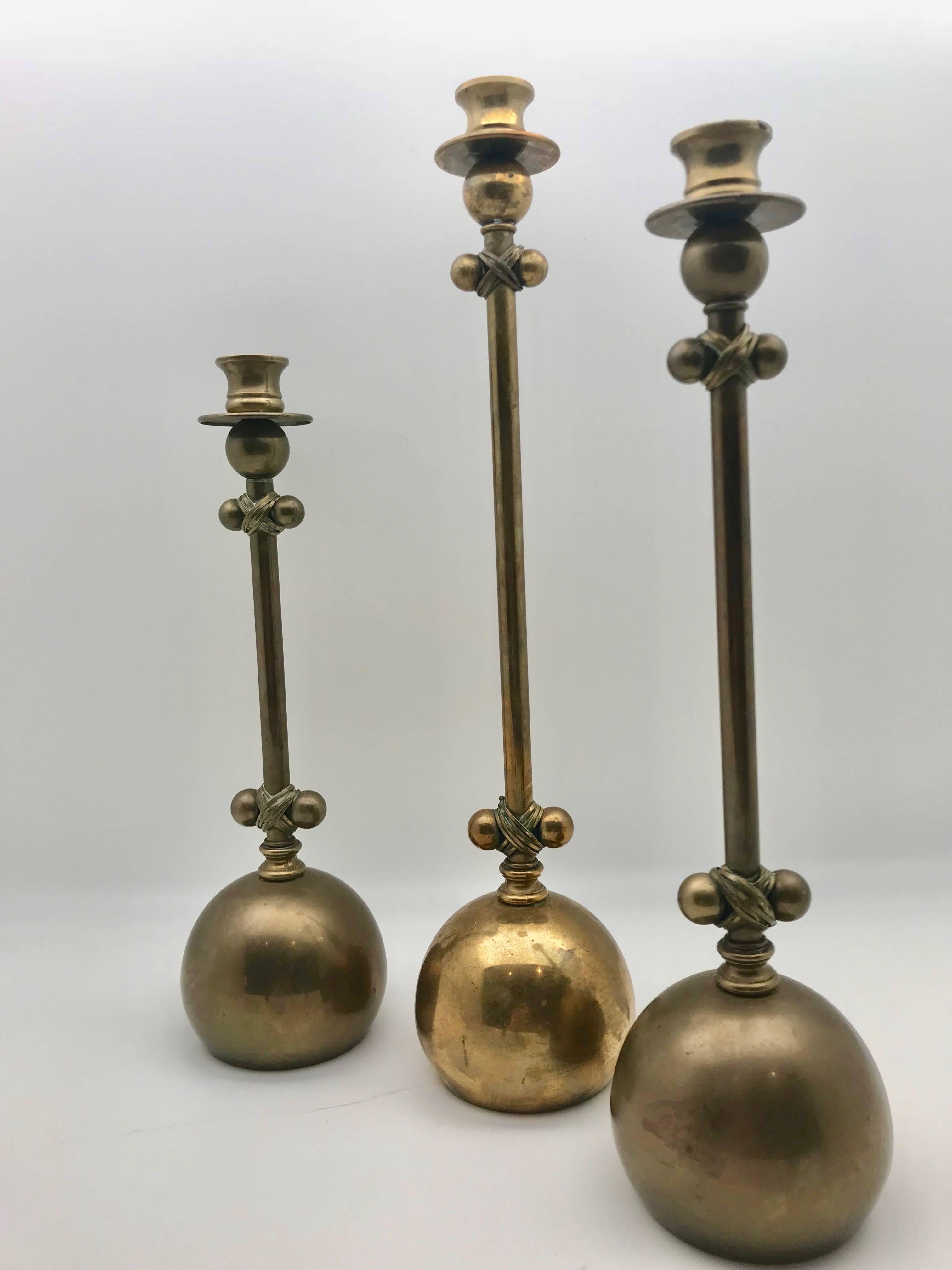 An unusual set of three midcentury brass six balled candlesticks, attributed to Chapman Co. All three have different heights- 17