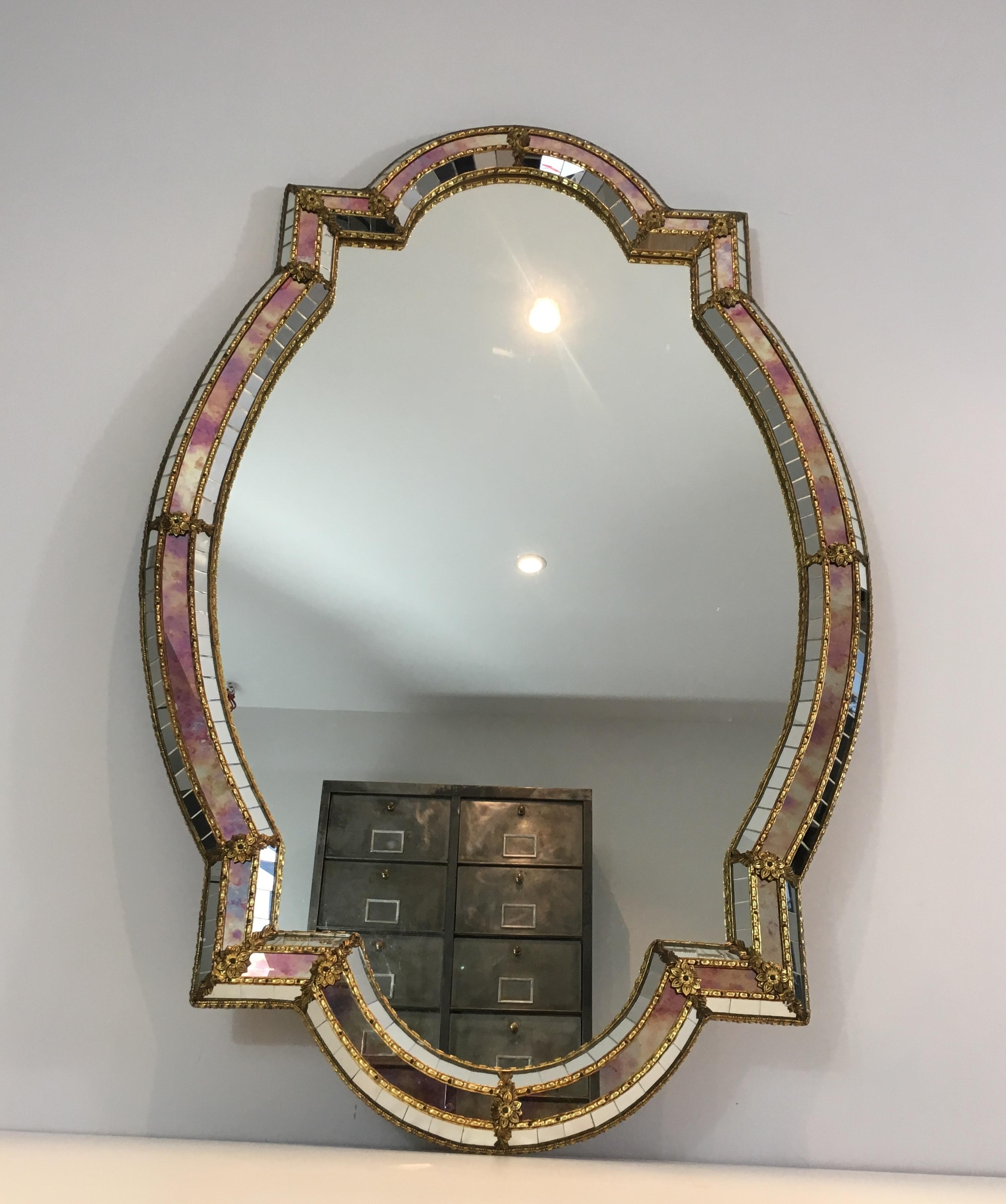 This beautiful and very decorative mirror is made of multi-faceted mirrors constituted of mirror mosaics with purple-pink reflects, brass flowers and garlands. This is a French work, circa 1970.