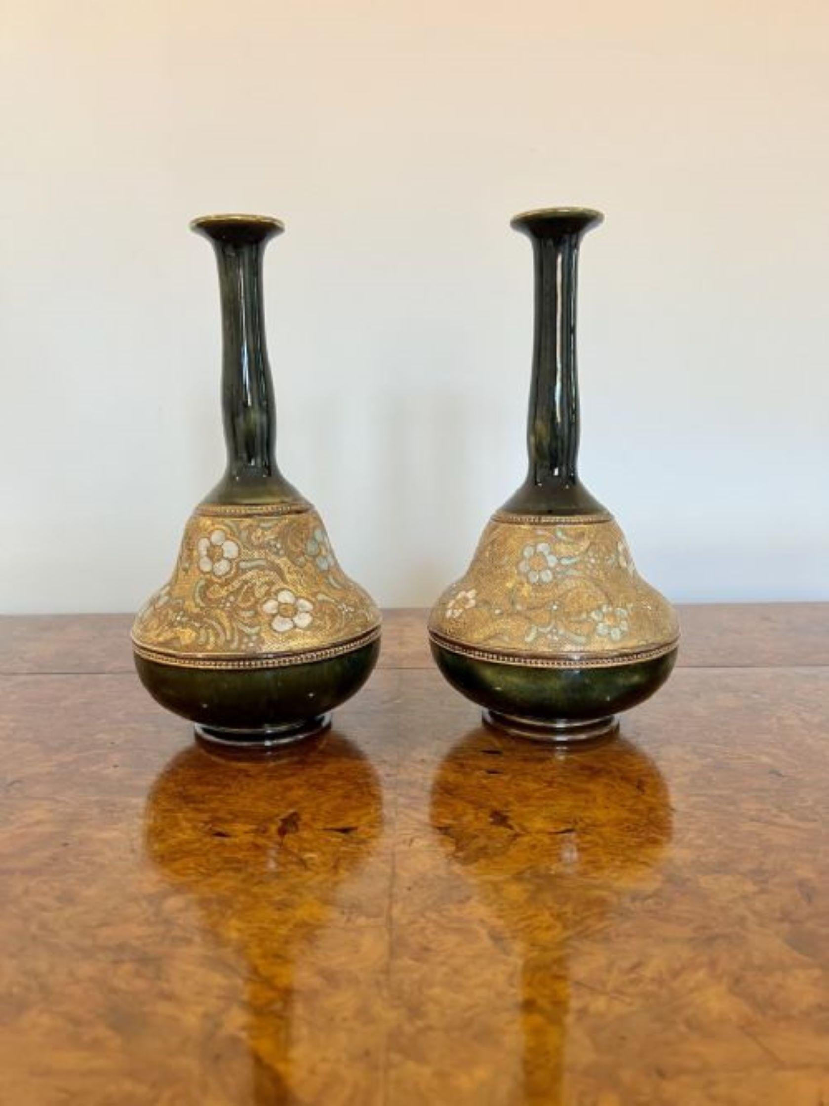 Unusual shaped pair of quality antique Doulton vases having a lovely pair of unusual shaped antique Royal Doulton vases having a band of green and white flowers on a golden background to the centre of the vase and a dark green glaze with gold