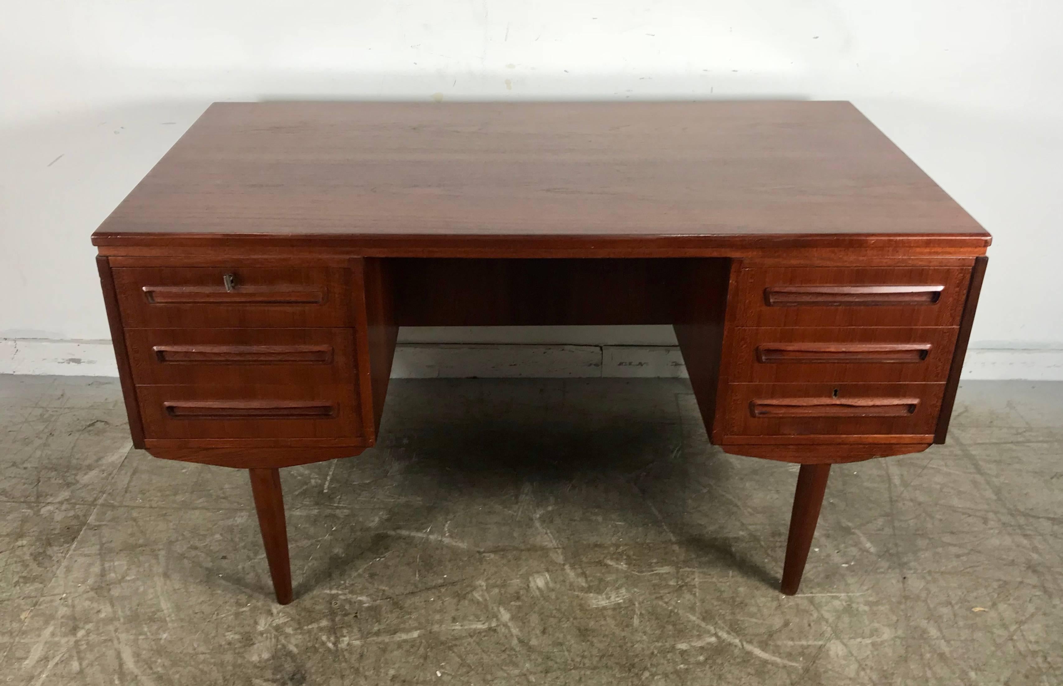 Unusual six-drawer Danish desk with front storage cubby by Gunni Omann, top left drawer locks, retains original key, superior quality and construction, unusual drop down door (bar) feature to front of desk, hand delivery avail to New York City or