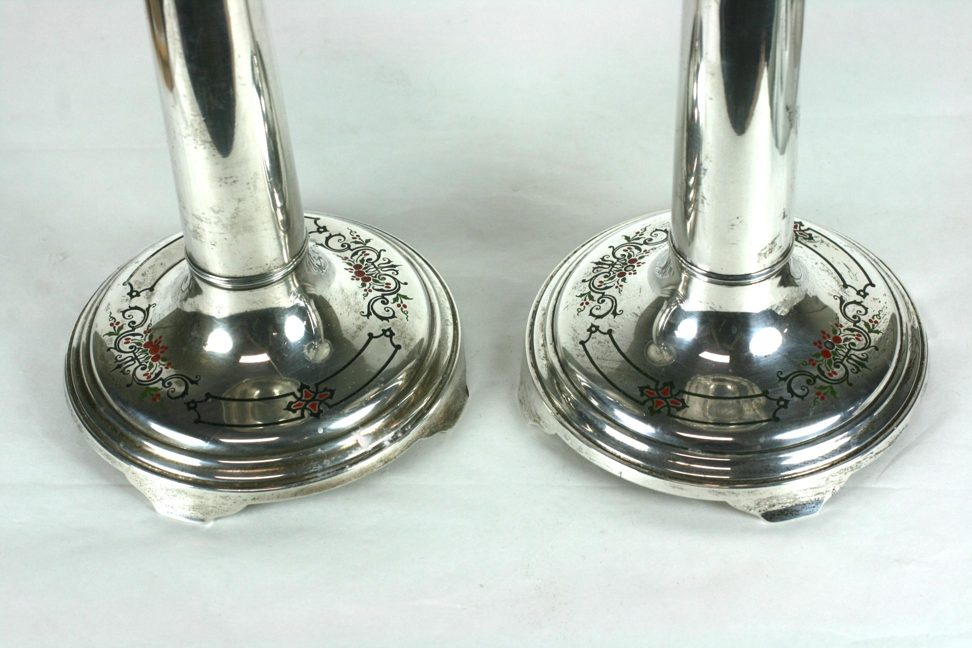 Unusual pair of elegant International sterling candlesticks which have cement filled shafts for stability. The bases are enameled with red and evergreen enamel designs with garlands and basket motifs.
Lovely quality heavy gauge construction with