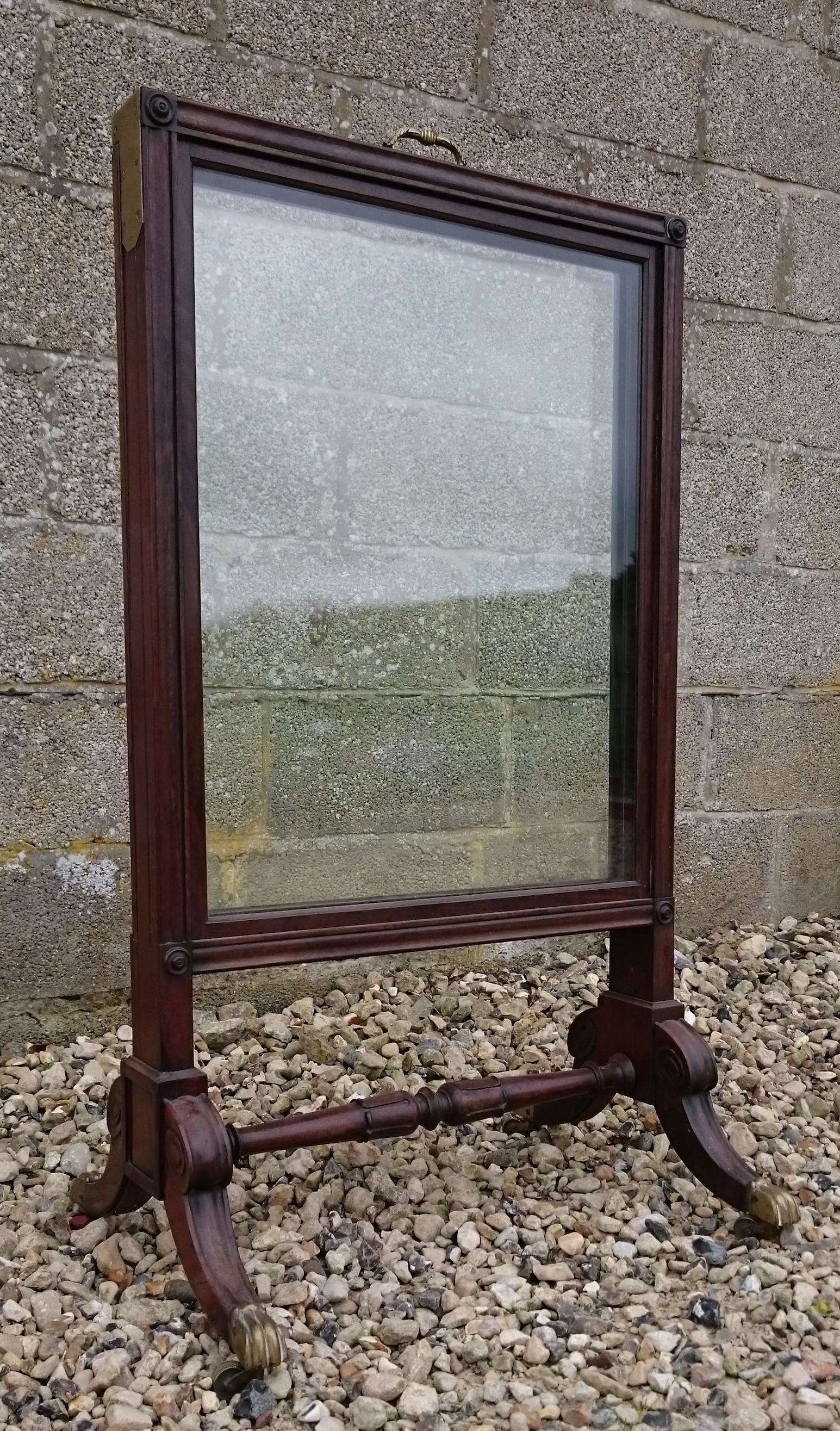 Unusual antique fire screen comprising of three glass sections, two of which slide out from the centre section. The end support with central bar format is pleasing to the eye. The mahogany is very fine quality and the decoration is finely carved.