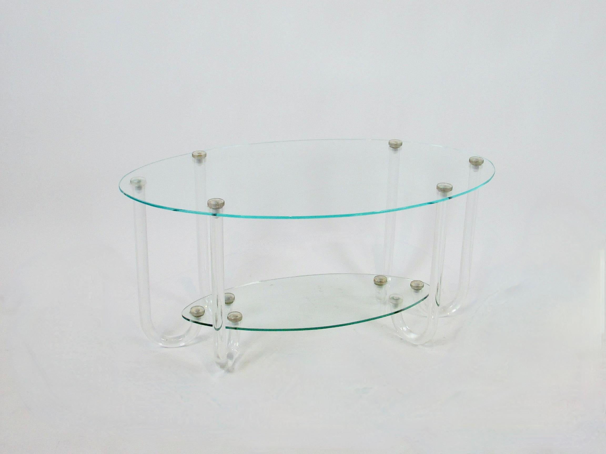 Two tier oval top ocasional table on six curved lucite legs . To my surprise the top tier appears to be acrylic . Originally thought it to be glass with the green edge matching the lower tier which is glass . Top is immaculate with no scratch or