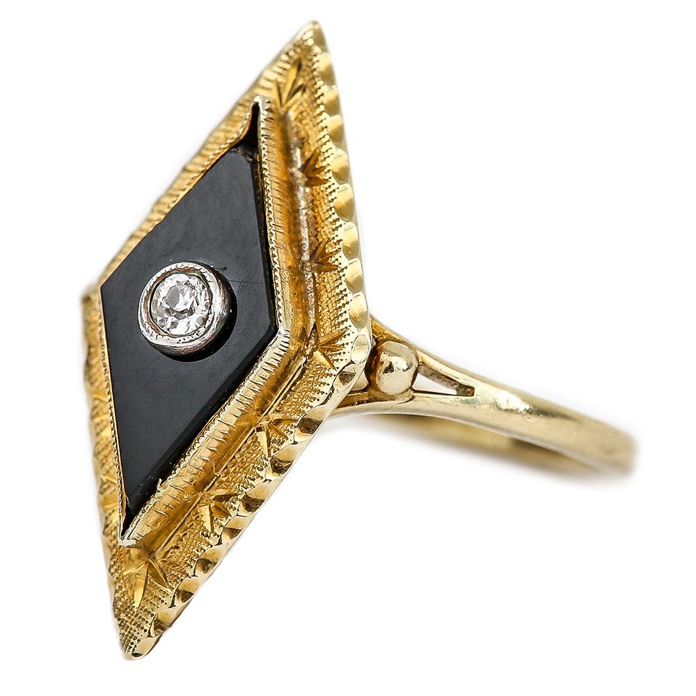 An unusual 18 karat gold Victorian onyx and diamond, diamond shaped ring. It has a chased border that would have been hand tooled and finished in the later part of the 19th century (1880-1890). In the centre of the onyx diamond shape is a small