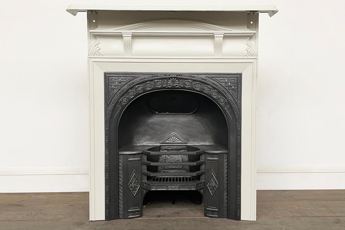 An unusual Victorian cast iron combination fireplace in the early 19th century style with an arched hob register grate and elegant surround. Circa 1880. The grate has been finished with traditional black grate polish and the surround primed with a