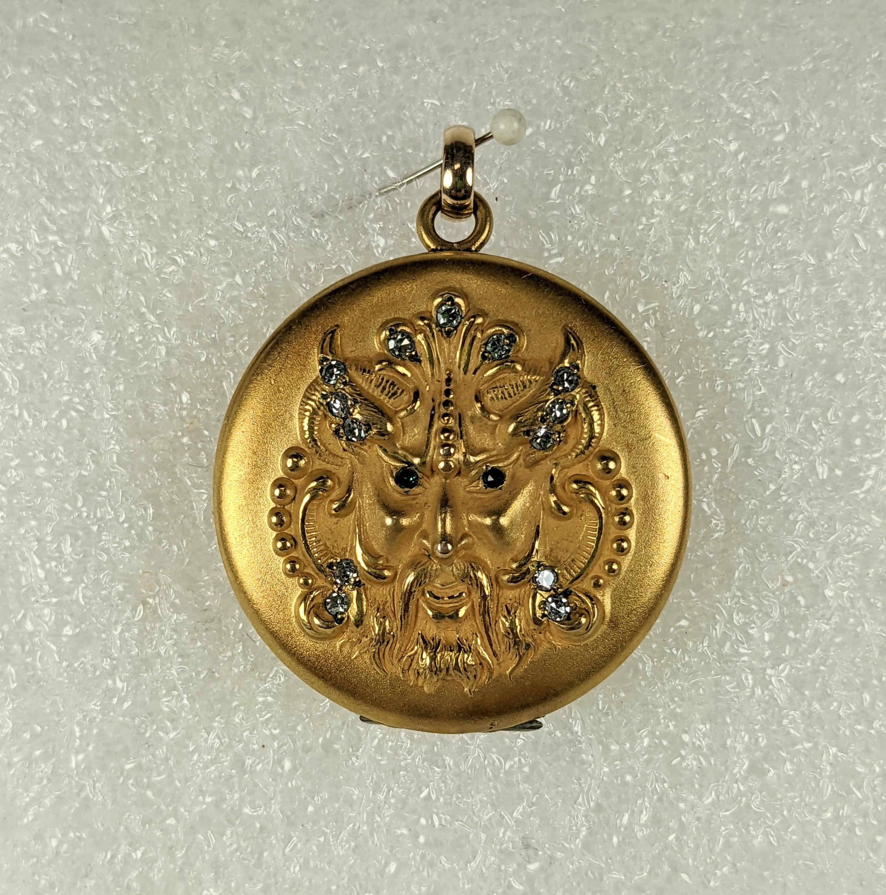 Super unusual Victorian Devil motif locket highlighted with green eyes and crystal pastes from the late 19th Century set in gold filled metal. Excellent condition. 1.25