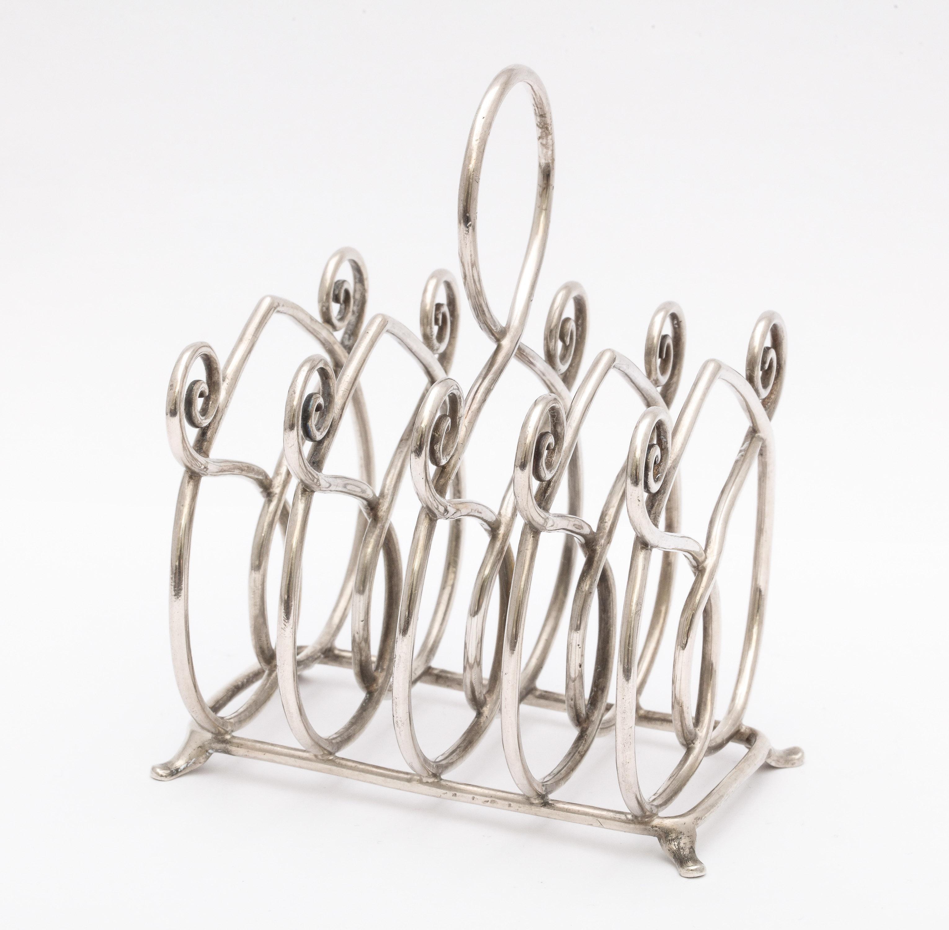 Unusual, Victorian, footed, sterling silver toast rack Gorham Manufacturing Company, Providence, Rhode Island, circa 1895. Sterling silver wires that separate slices of toast are designed to look like upside-down hearts. Measures 3 1/2 inches wide x