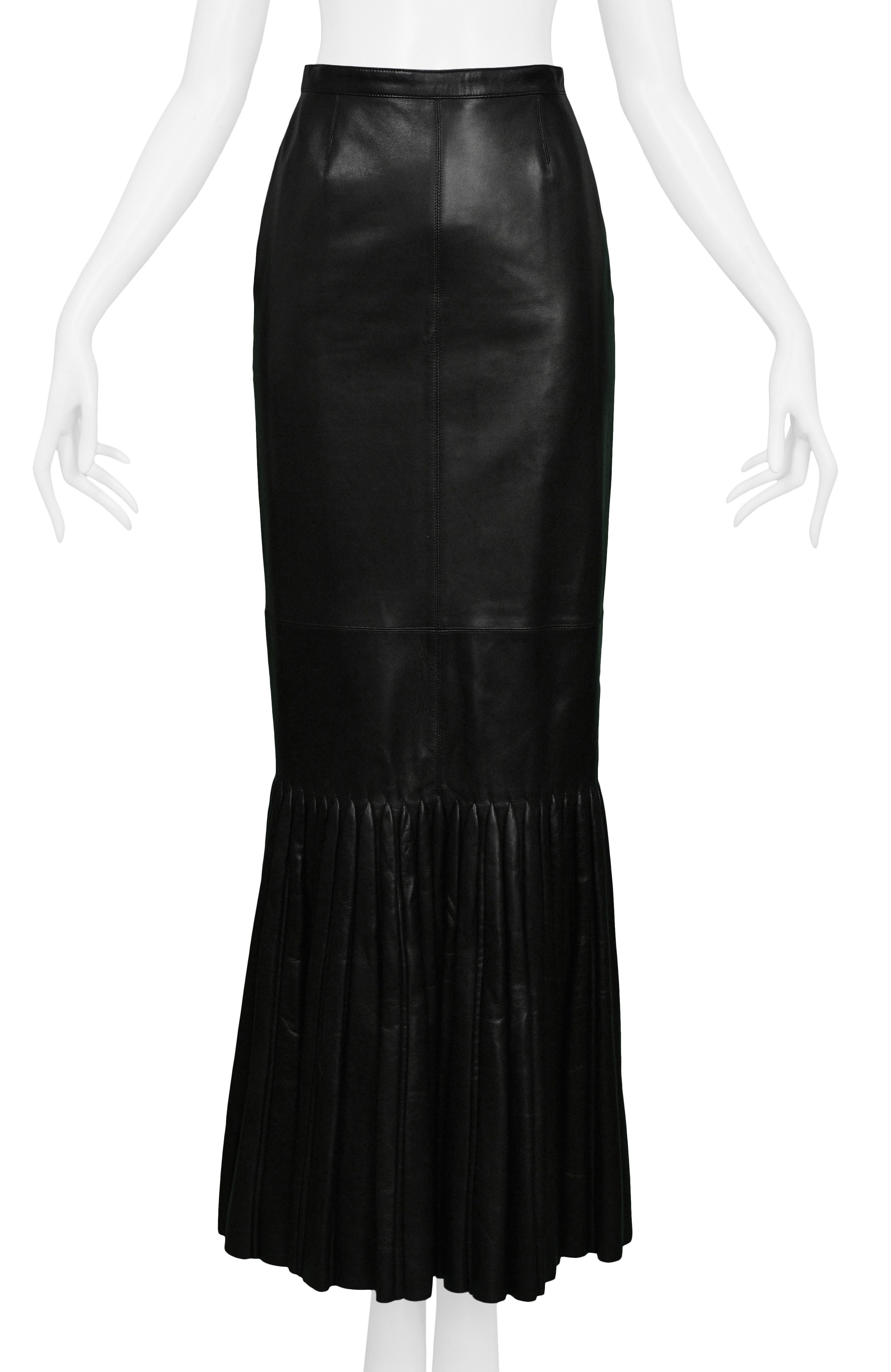 Vintage Azzedine Alaia black leather mermaid skirt with pleated flounce. This skirt has paneling along the front and back midsection and is made of luxurious leather. This skirt features a snap button closure and a center zipper.  

Excellent