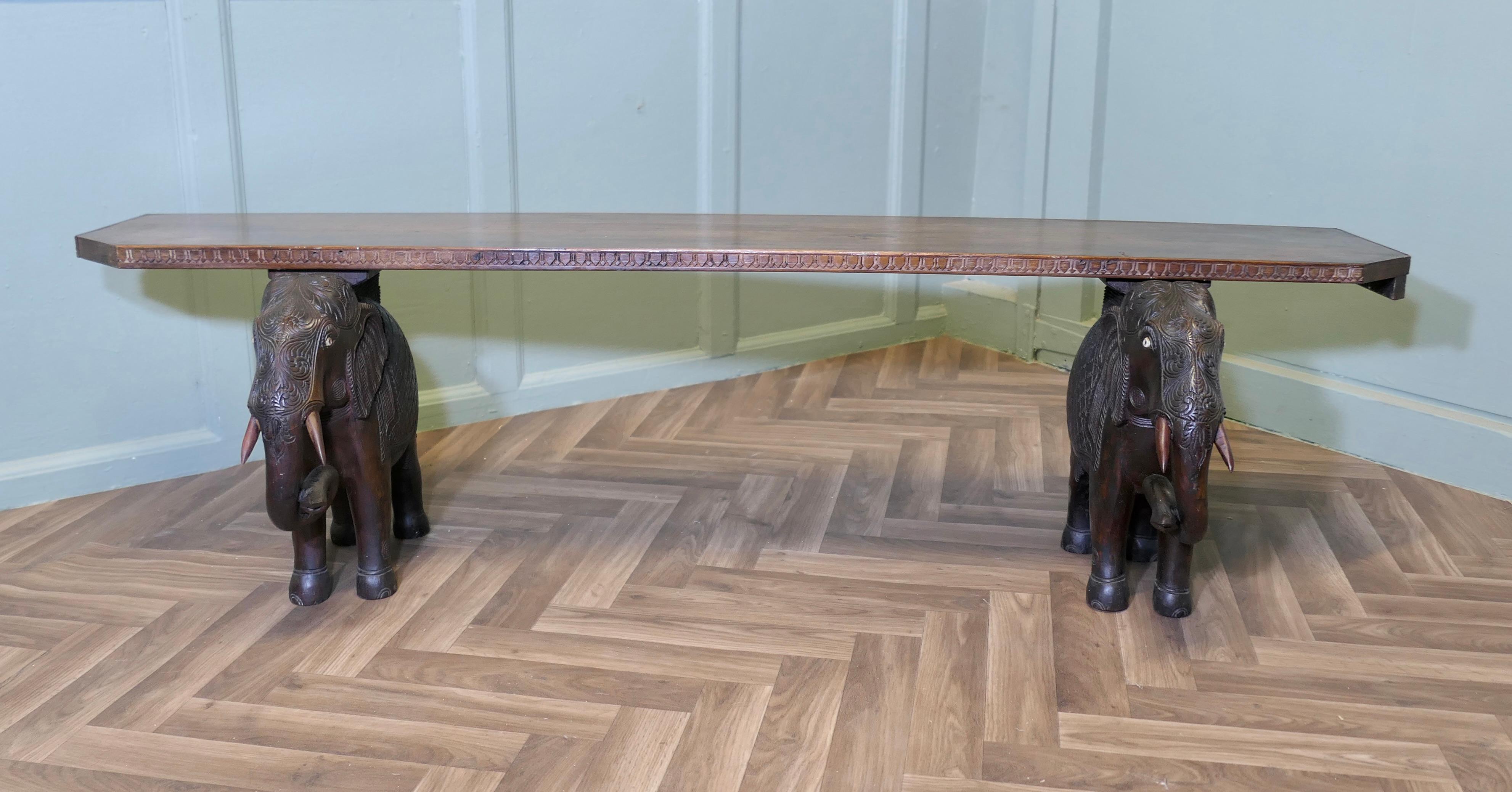 Unusual Window Seat or Hall Bench with Carved Elephants

This is a lovely piece, the bench has a long plank seat with a carved edge set on the backs of 2 handsome elephants, the elephants are hand carved in their formal dress
This is a good sturdy