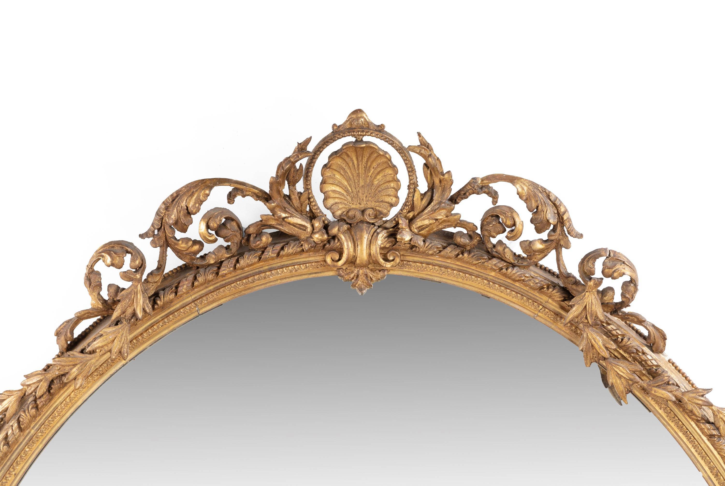 An unusually large, French, oval giltwood mirror, the top with finely carved swags and decoration. The outer rim with continuous rope and leaf decoration. Original gilding.
 