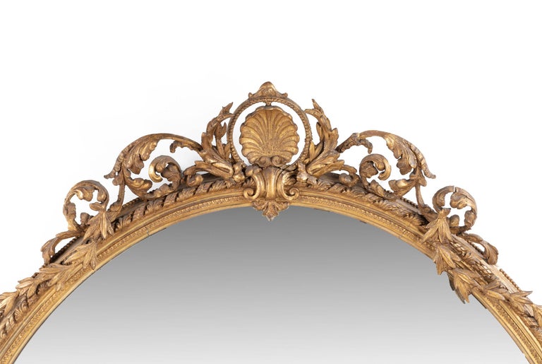 An unusually large, French, oval giltwood mirror, the top with finely carved swags and decoration. The outer rim with continuous rope and leaf decoration. Original gilding.
 