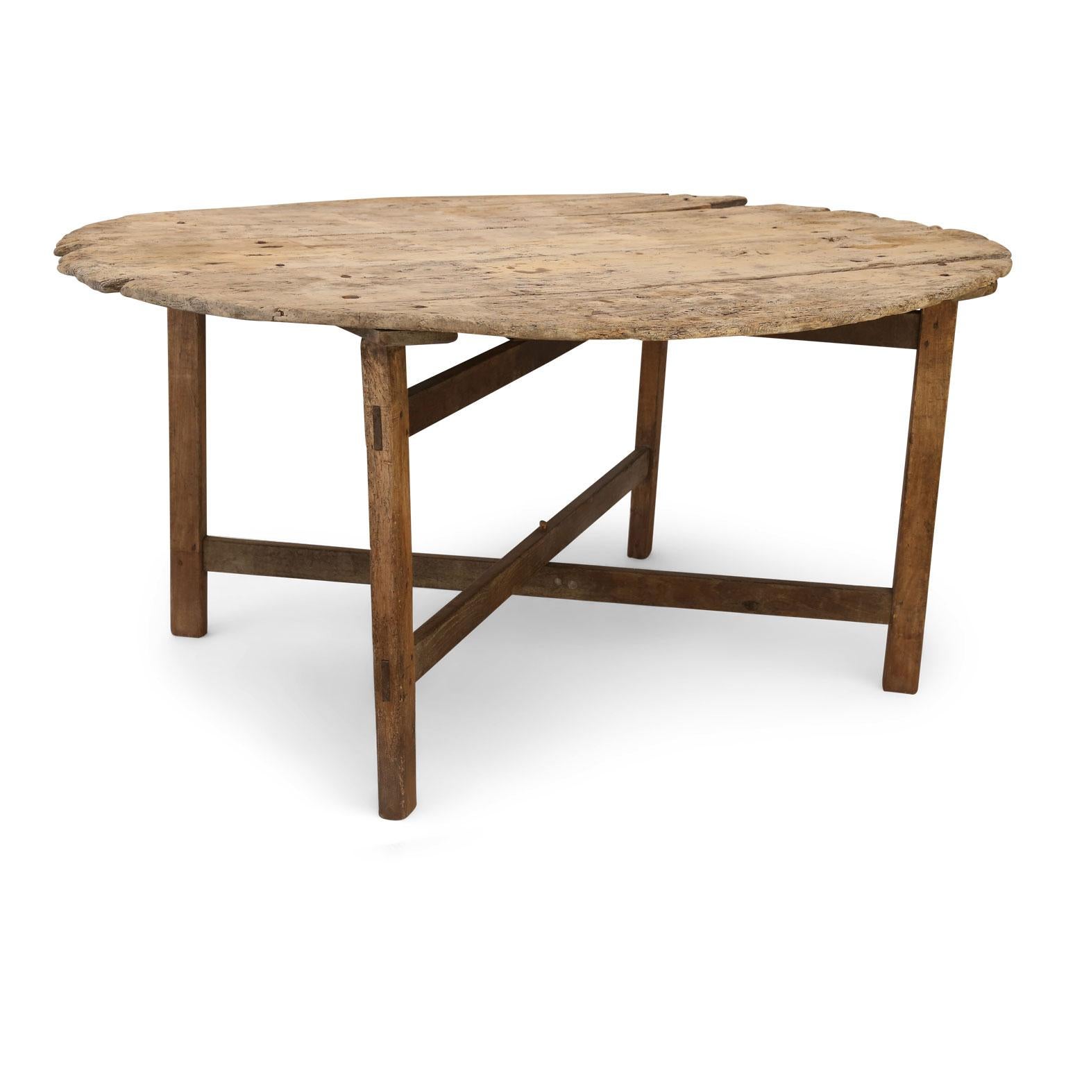 Unusually large early vendange table dating to early 19th century, France. Understated simple lines and an exquisite naturally weathered and sun-bleached pale, dry patina. Collapsible base, irregular edges and age separation/shrinkage between top's