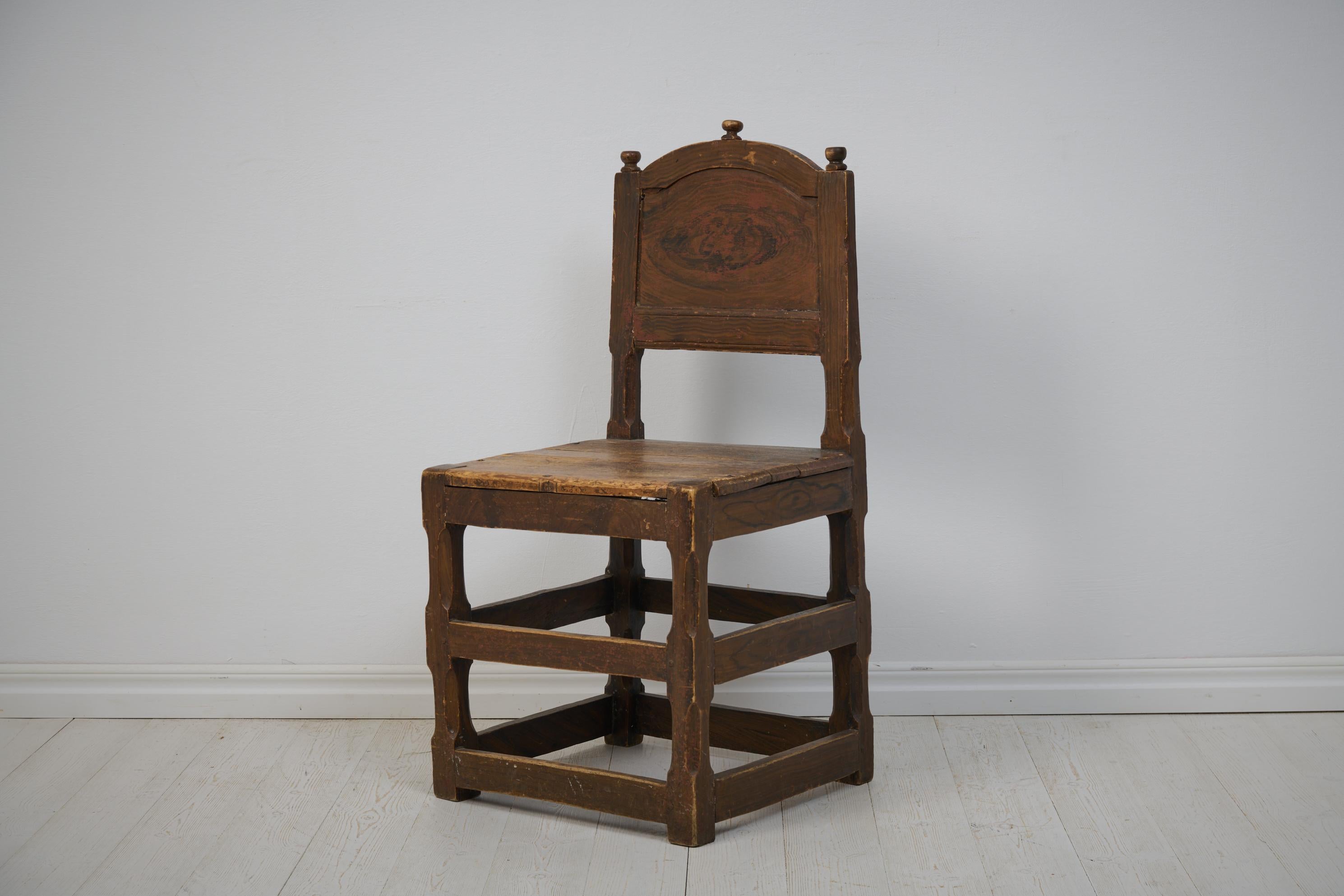 Chaise baroque suédoise d'une taille inhabituelle, fabriquée vers 1770. La chaise a un cadre en pin massif avec une fausse peinture d'origine. Le peintre a fait une interprétation libre du noyer. La peinture est abîmée par l'usage. La chaise est